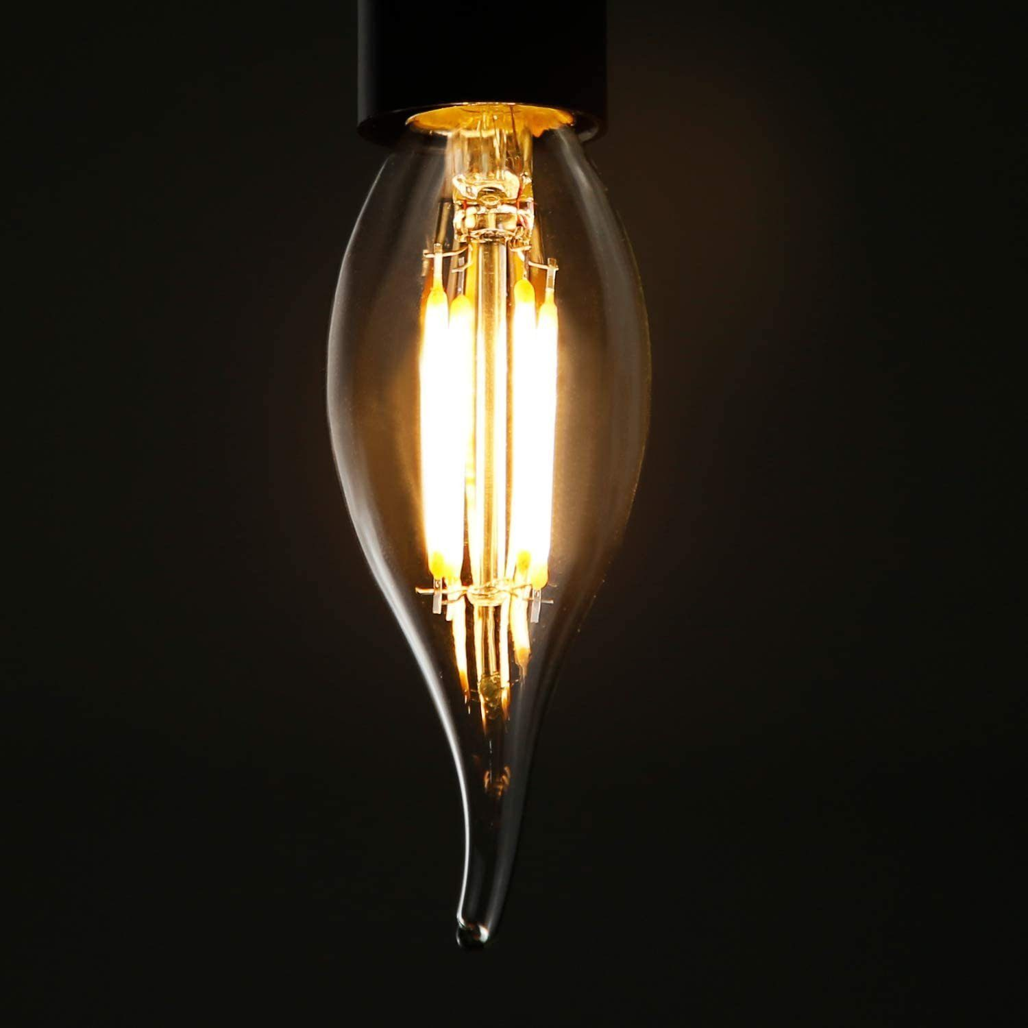 Una lampadina Edison accesa con bulbo in vetro trasparente e filamenti visibili su sfondo nero.