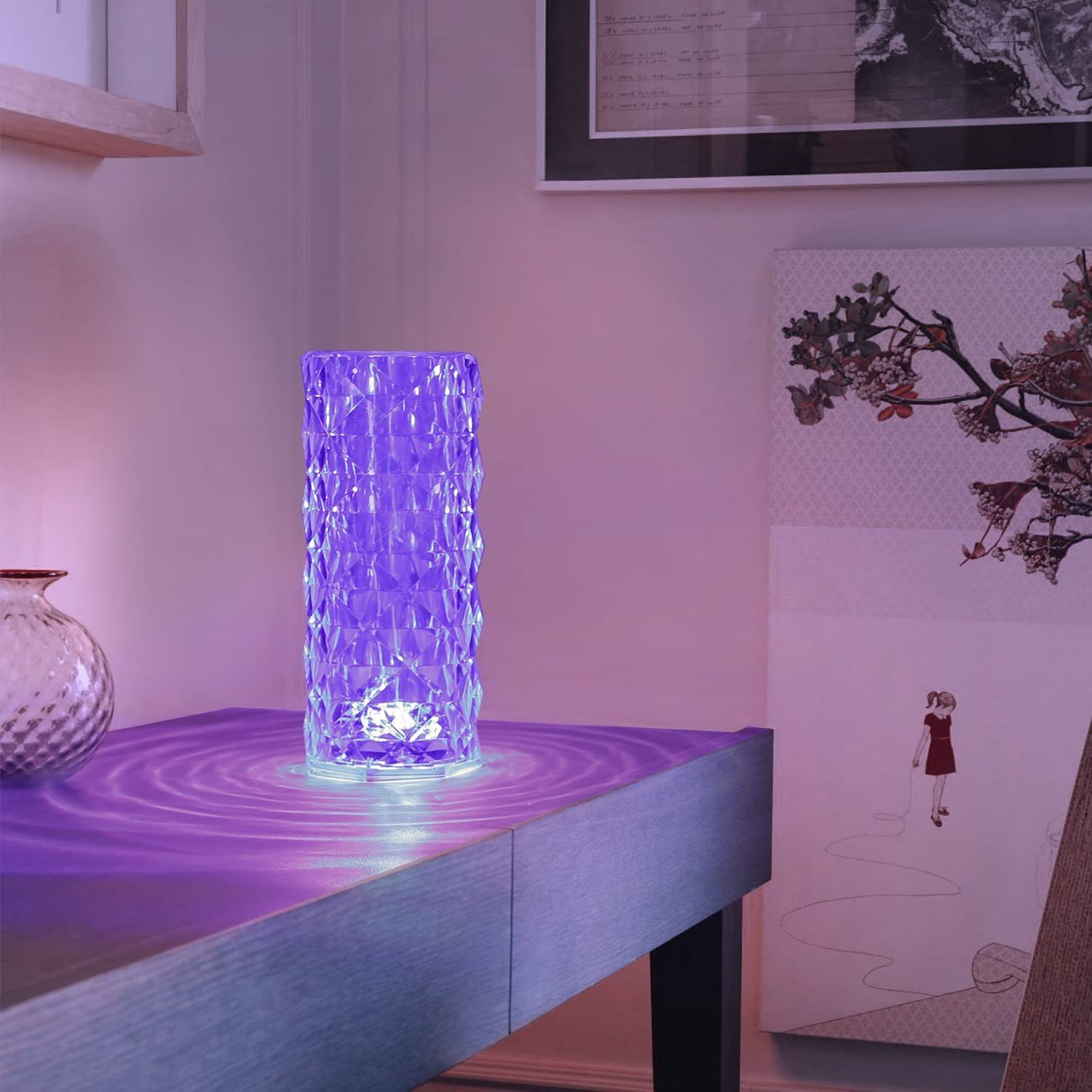 Una lampada di cristallo viola illumina un tavolo con increspature d'acqua. Arte a destra.