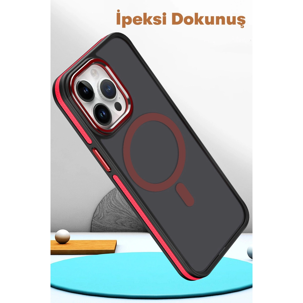 Kırmızı kenarlı ve MagSafe halkalı siyah iPhone kılıfı.