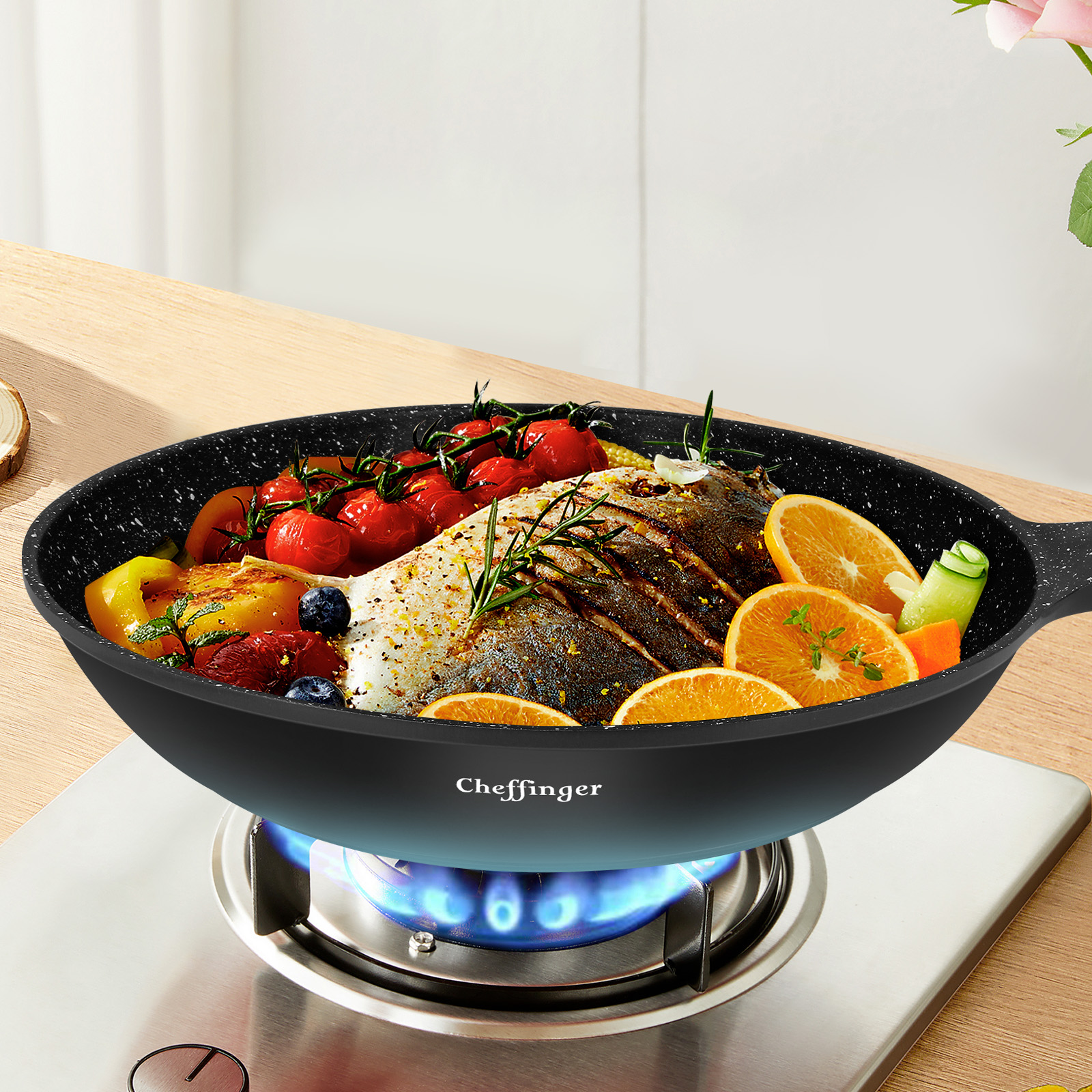 Poisson poêlé avec légumes et oranges dans une poêle sur une cuisinière à gaz.