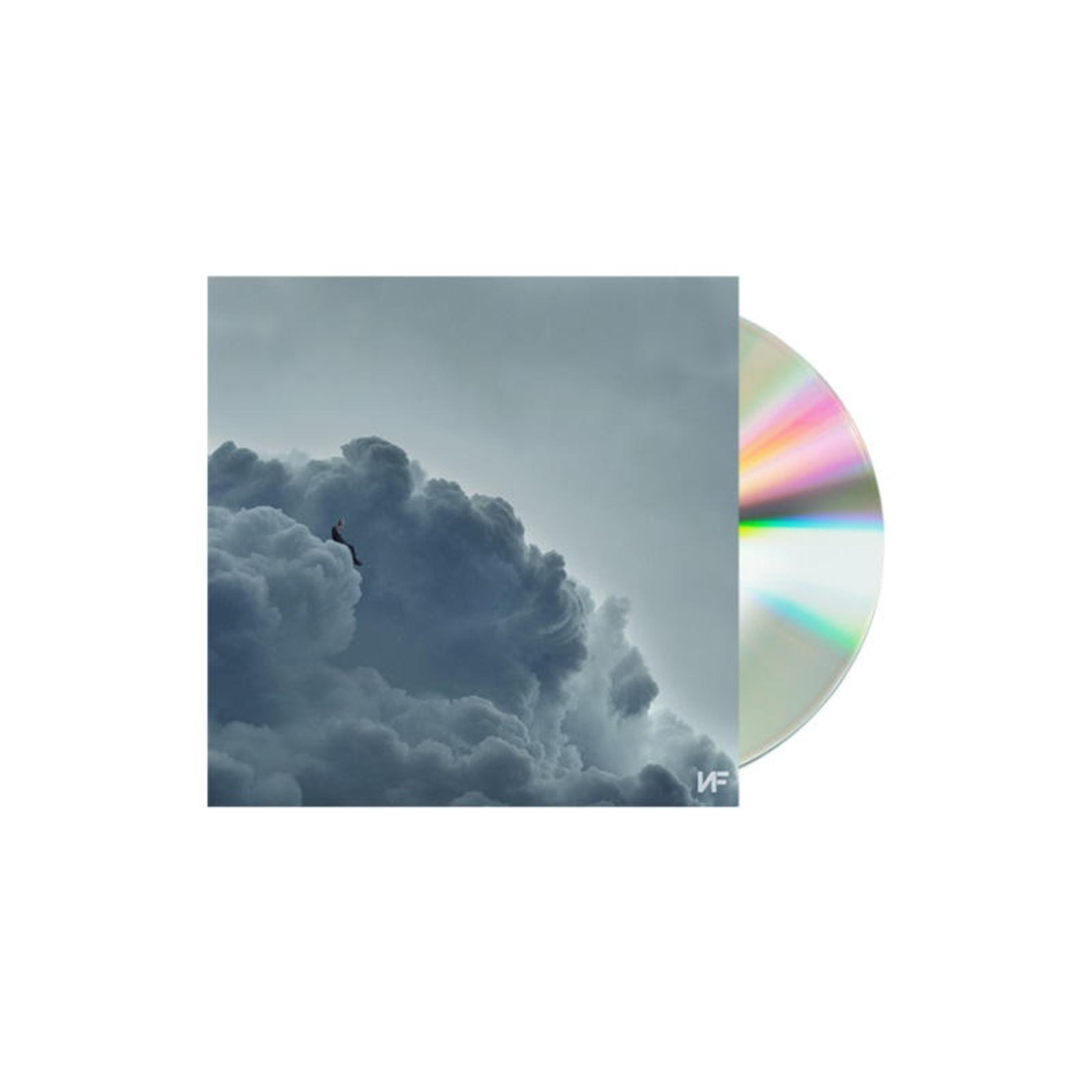 Un uomo seduto su una nuvola accanto a un CD con effetti arcobaleno.