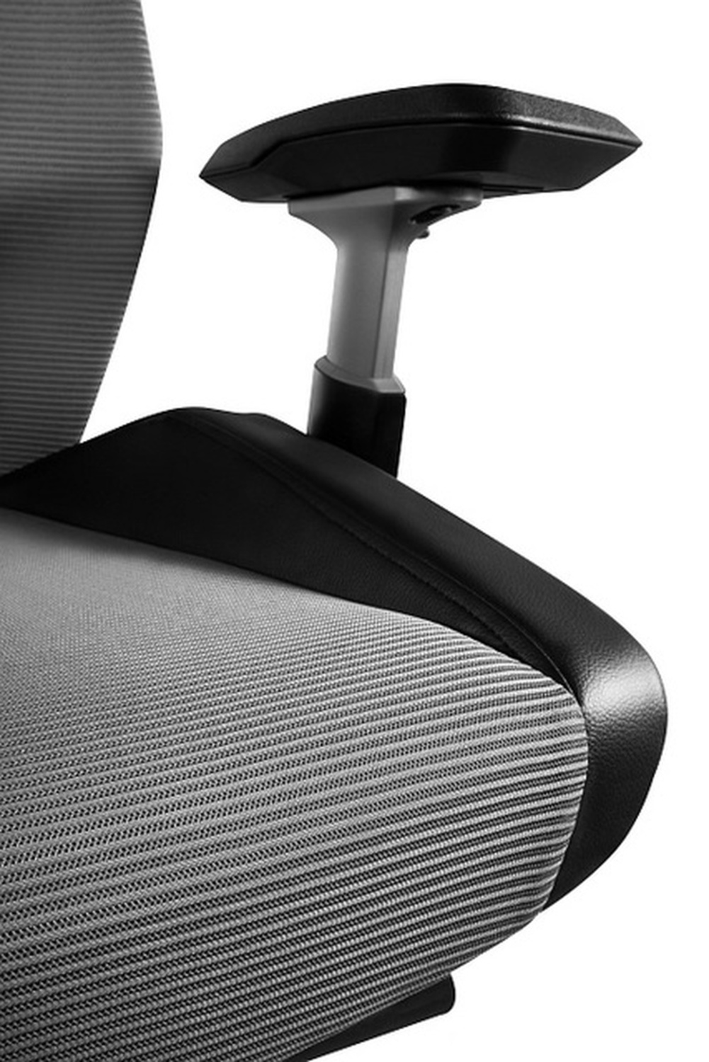 Szare krzesło biurowe z czarną skórzaną lamówką i regulowaną podłokietnik.