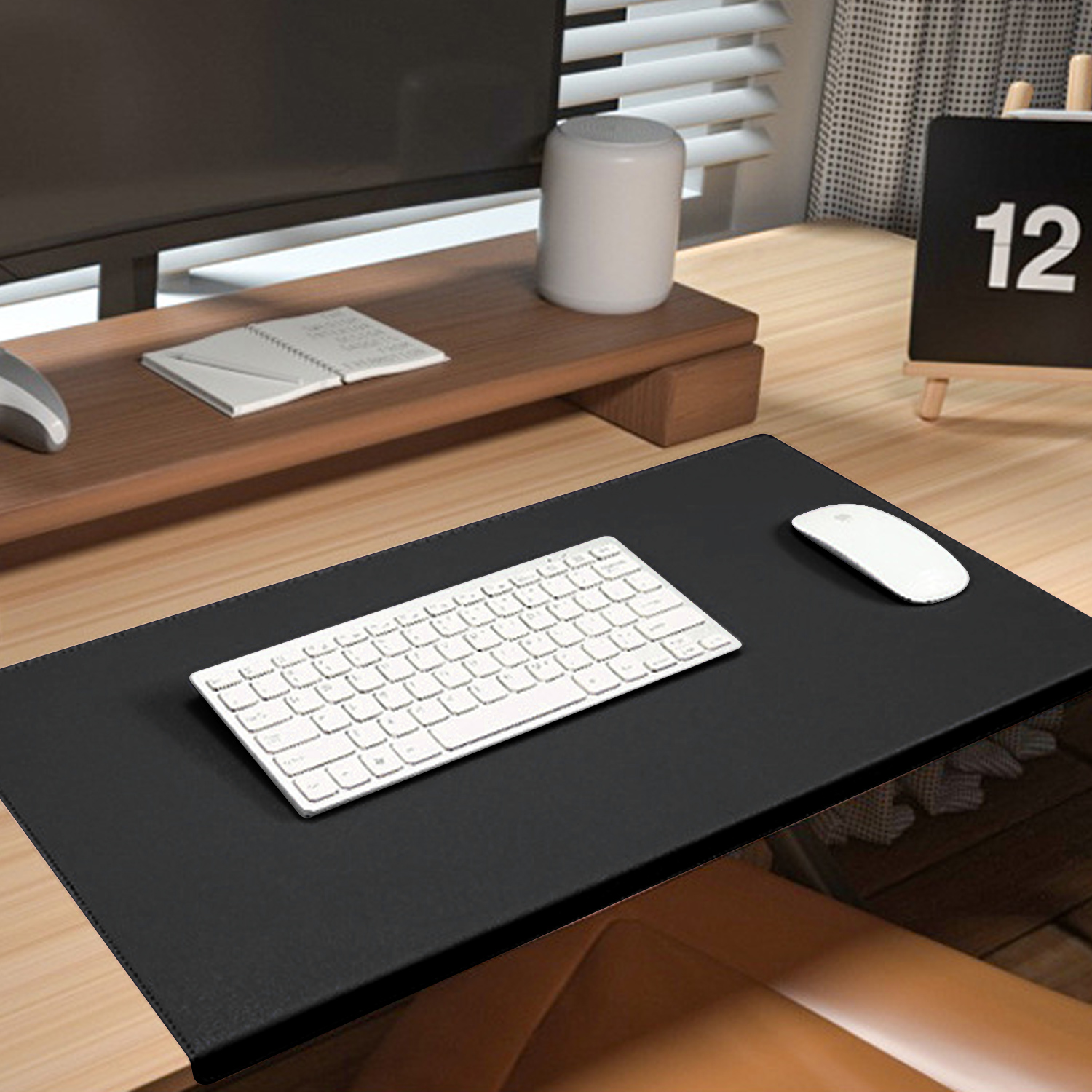 Biała klawiatura i mysz na czarnej podkładce na biurko.