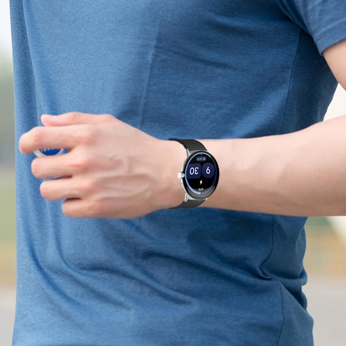 Eine Person trägt ein blaues Hemd und eine Smartwatch am linken Handgelenk.