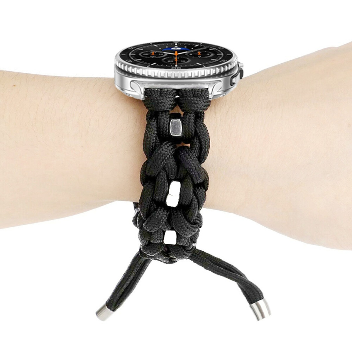 Un cinturino per orologio in paracord nero è attaccato a uno smartwatch argentato su un polso.