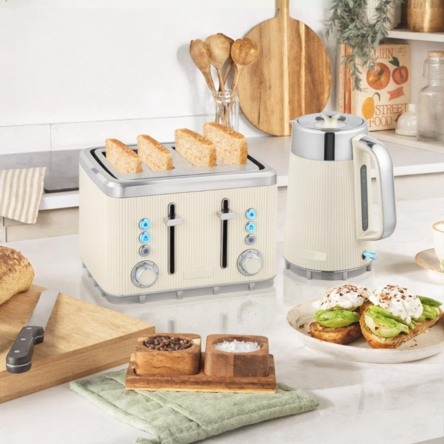 Ein cremefarbener Toaster mit vier Toastscheiben und ein Wasserkocher daneben.