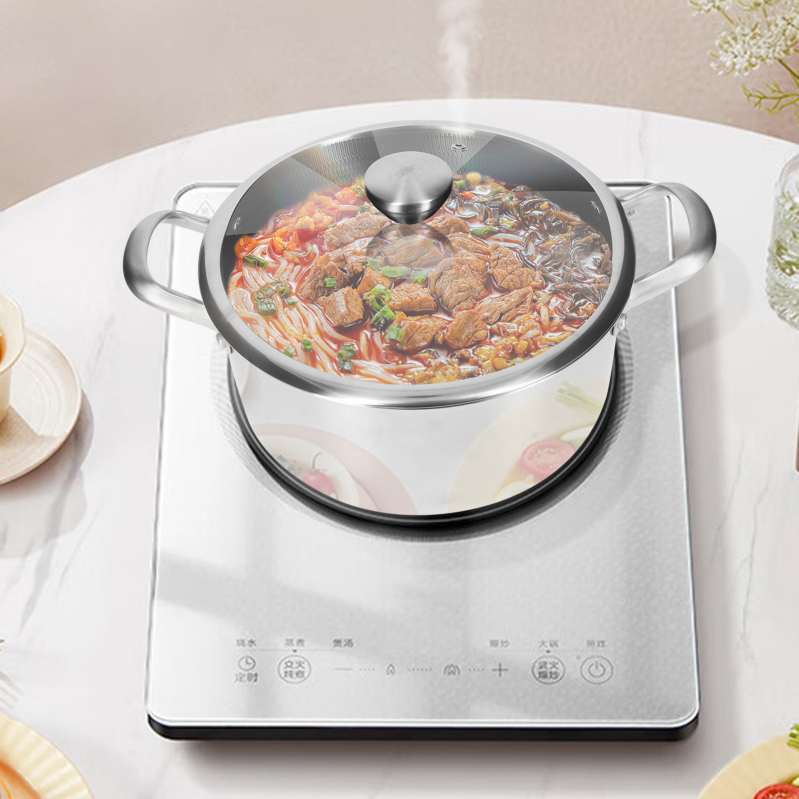 Una olla de sopa de fideos con carne y verduras está en una placa de inducción.