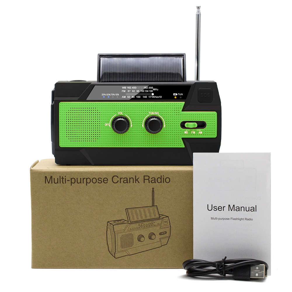 Grünes und schwarzes Kurbelradio mit Solarpanel, Benutzerhandbuch und USB-Kabel.