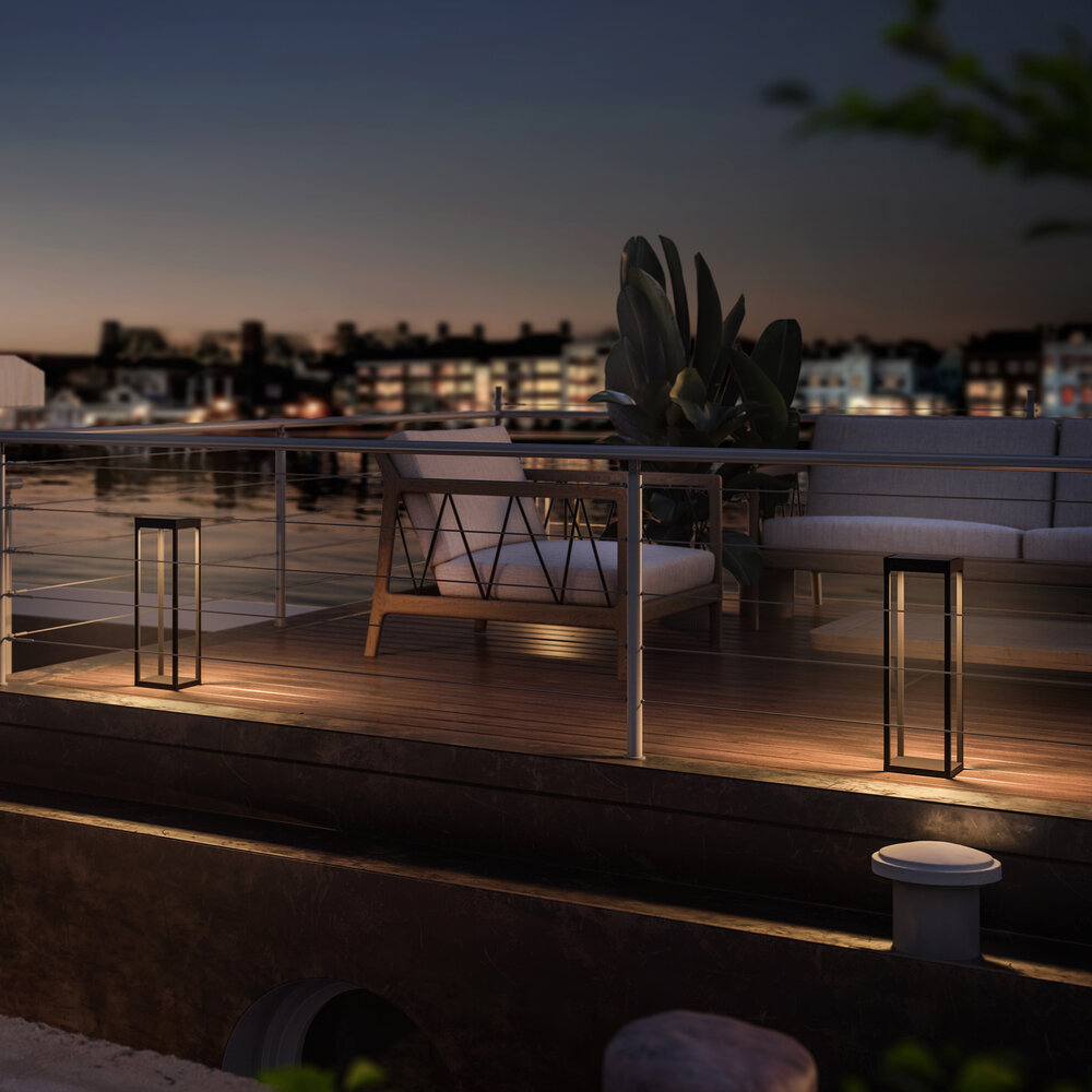 Eine moderne Terrasse bei Nacht mit Sitzgelegenheiten und Lichtern.