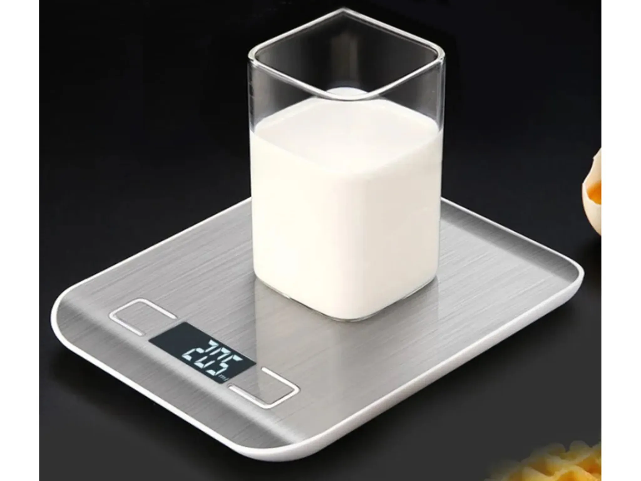 Ein Glas Milch auf einer digitalen Küchenwaage mit der Anzeige 205.