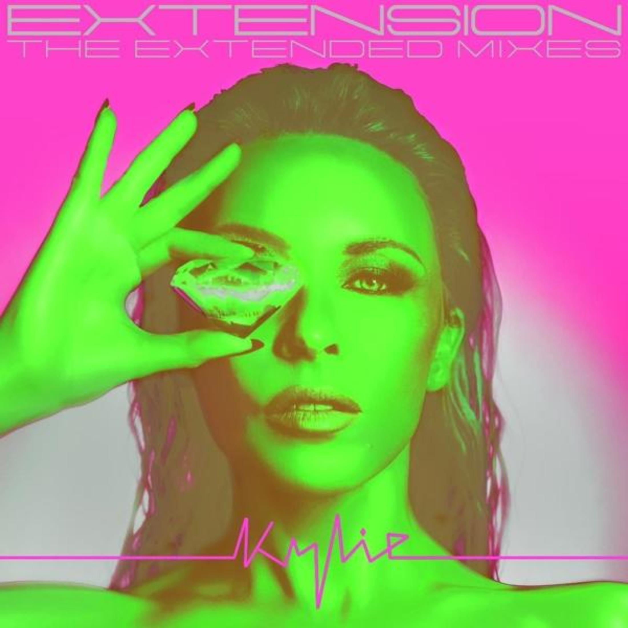 Una donna con la pelle verde tiene un diamante davanti all'occhio. Sfondo rosa neon.