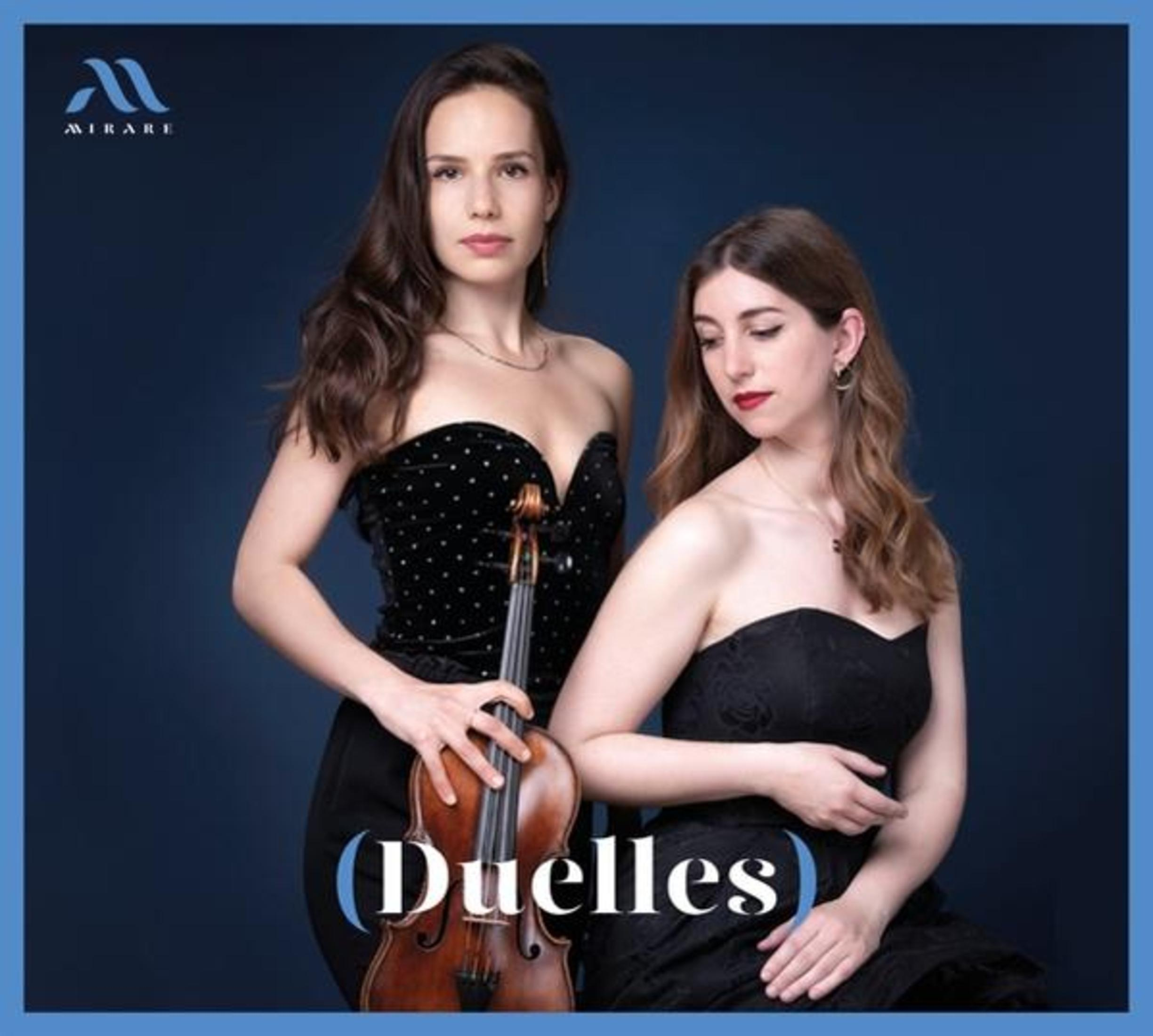 Due donne in abiti neri posano con un violino su sfondo blu scuro.