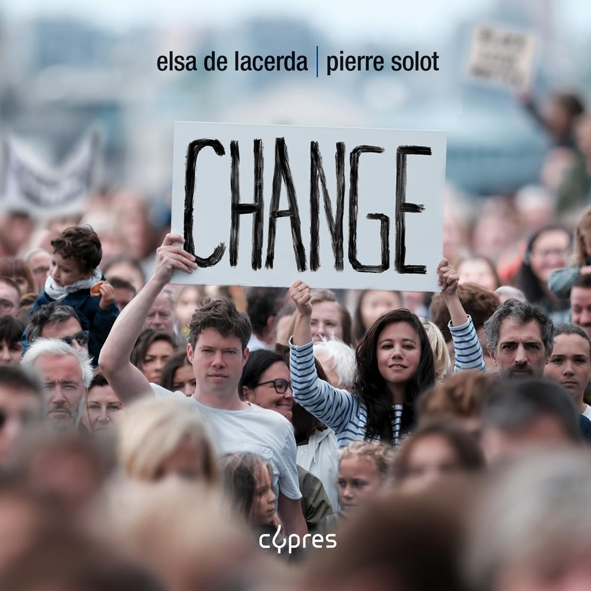 Una folla tiene in alto un cartello con scritto CHANGE.