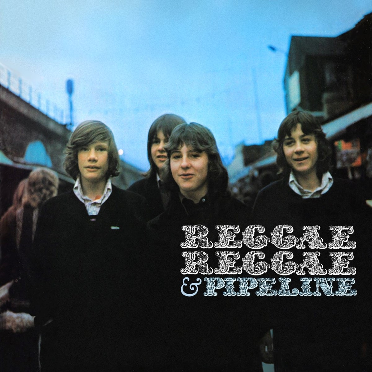 Quattro giovani in maglioni neri davanti a un cielo blu. Testo: REGGAE REGGAE & PIPELINE.