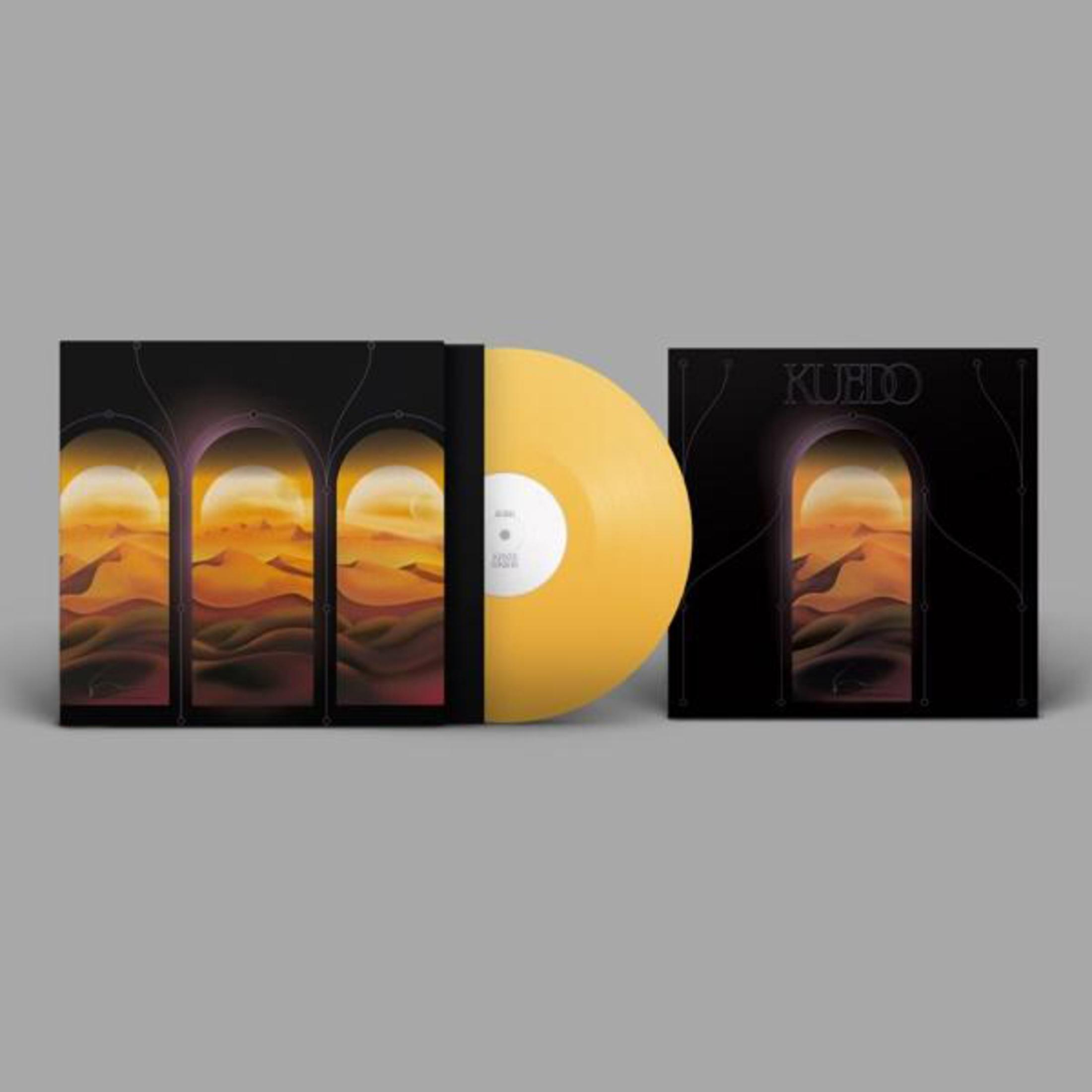 Disco in vinile giallo accanto a due copertine di album con paesaggio desertico attraverso archi.