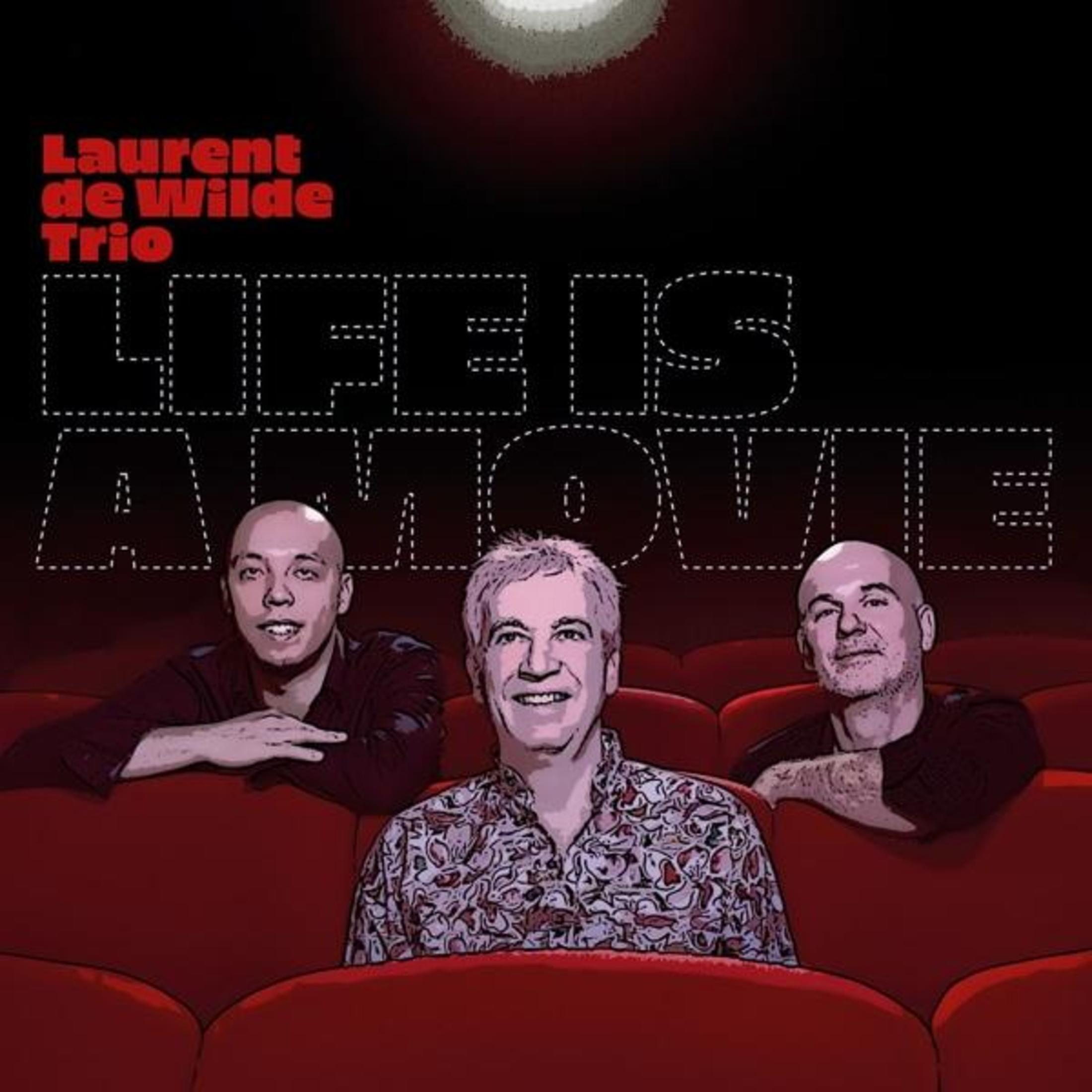 Tre uomini siedono su poltrone rosse da cinema. È visibile il titolo "LIFE IS A MOVIE".