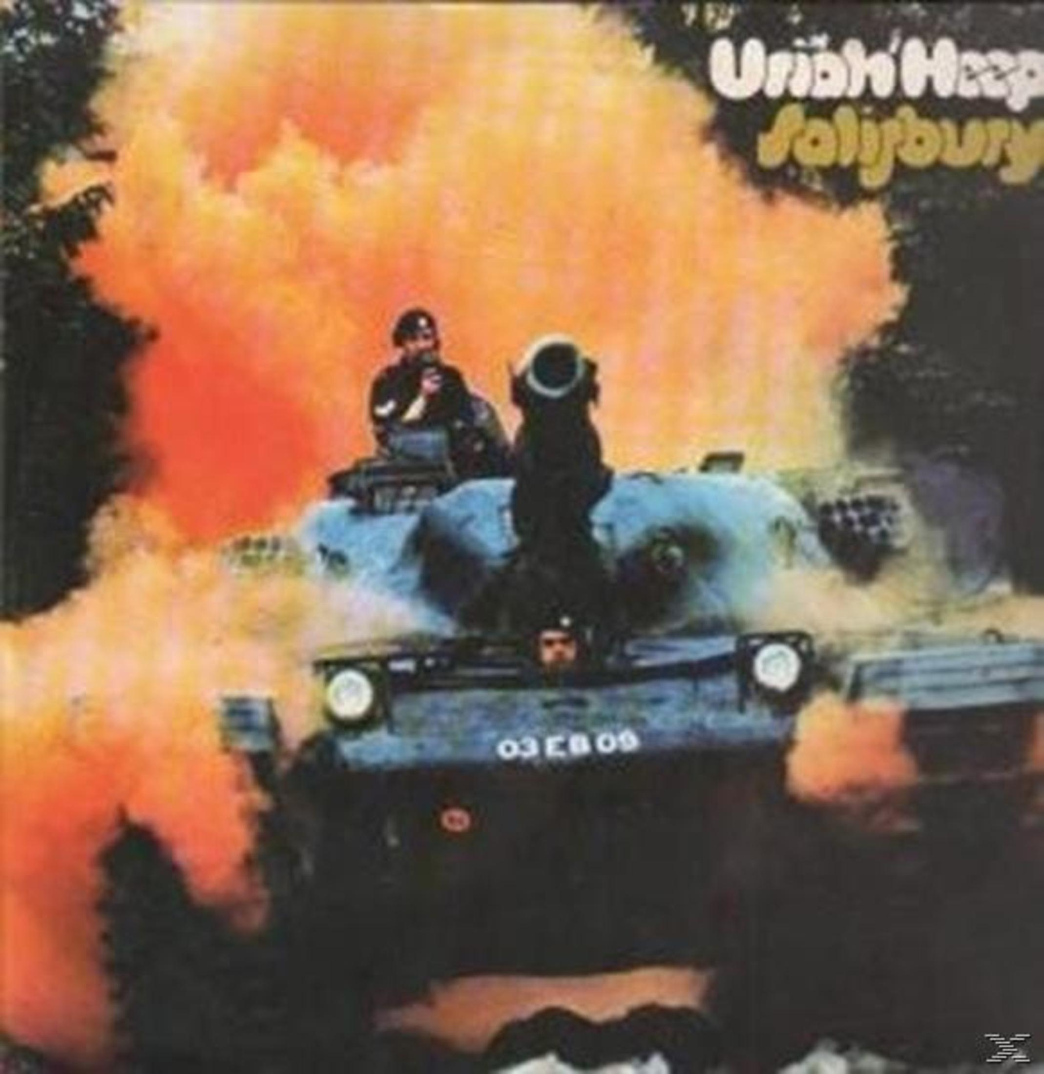 Un carro armato con due occupanti avanza tra fumo arancione. Testo Uriah Heep Salisbury sopra.
