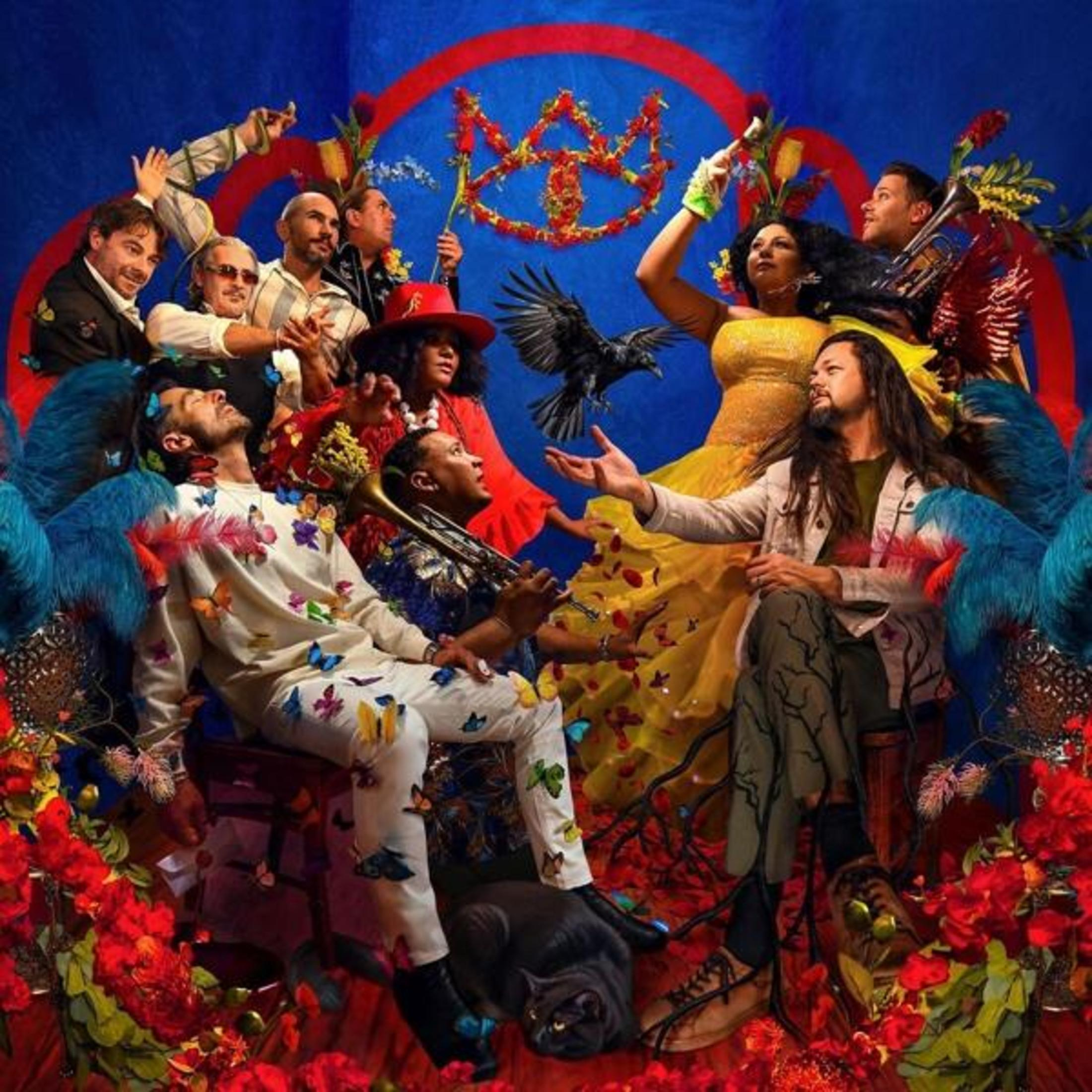 Un gruppo di persone in abiti colorati, circondato da fiori e piume.