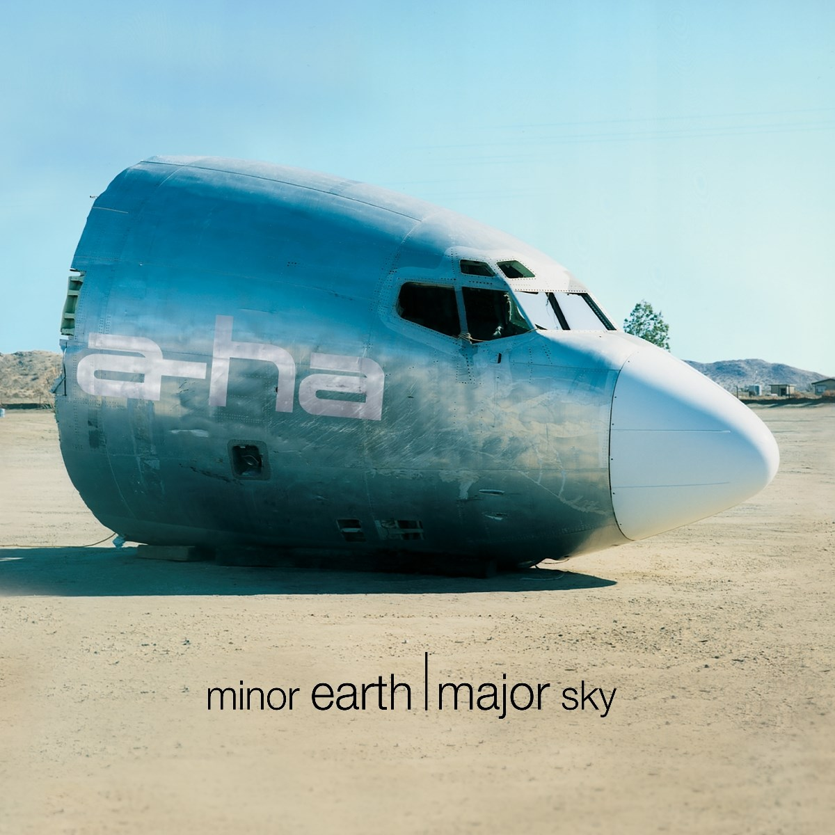 Muso d'aereo in un campo, con nome band a-ha e titolo album.