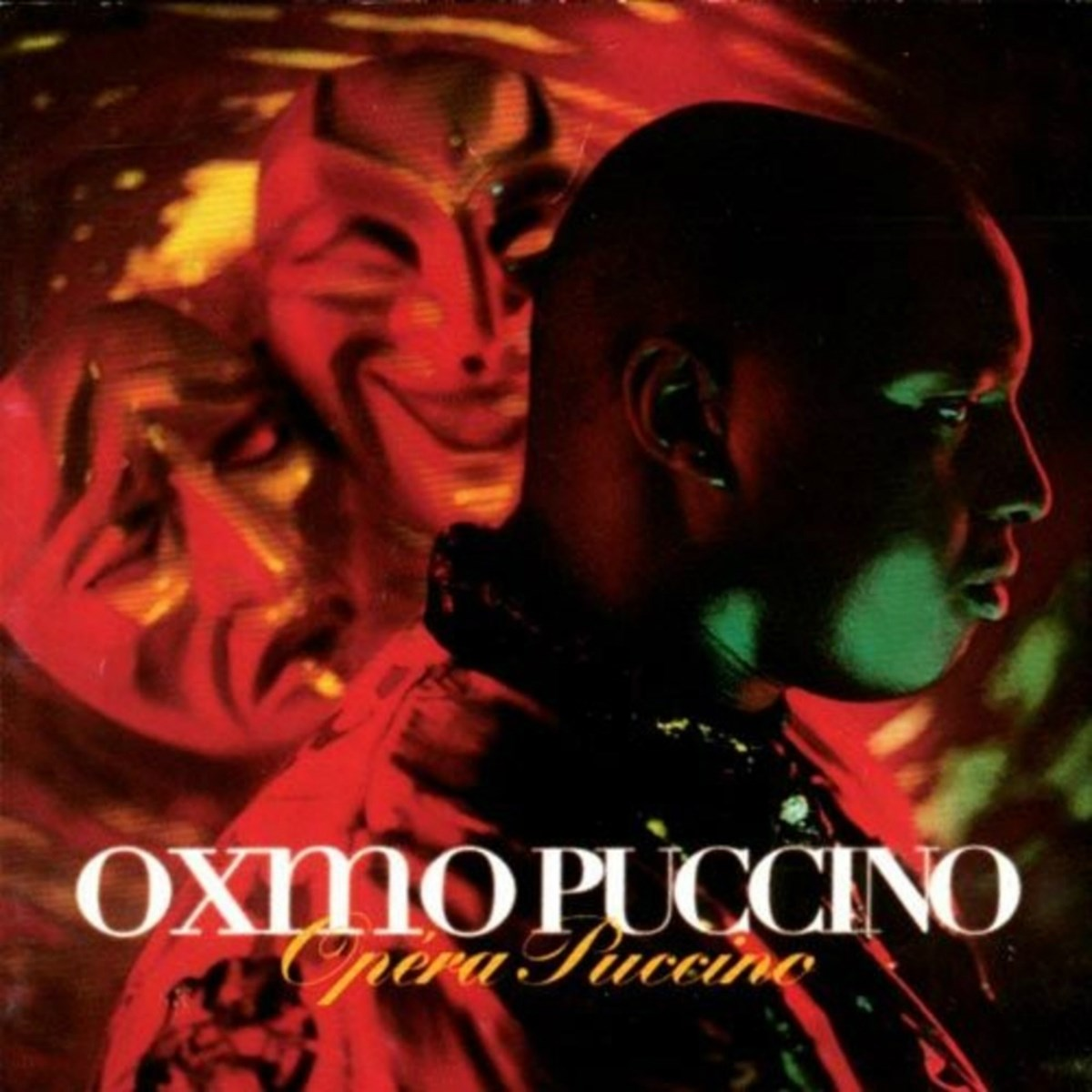 Uomo di profilo davanti a maschere rosse, con testo "Oxmo Puccino Opera Puccino".
