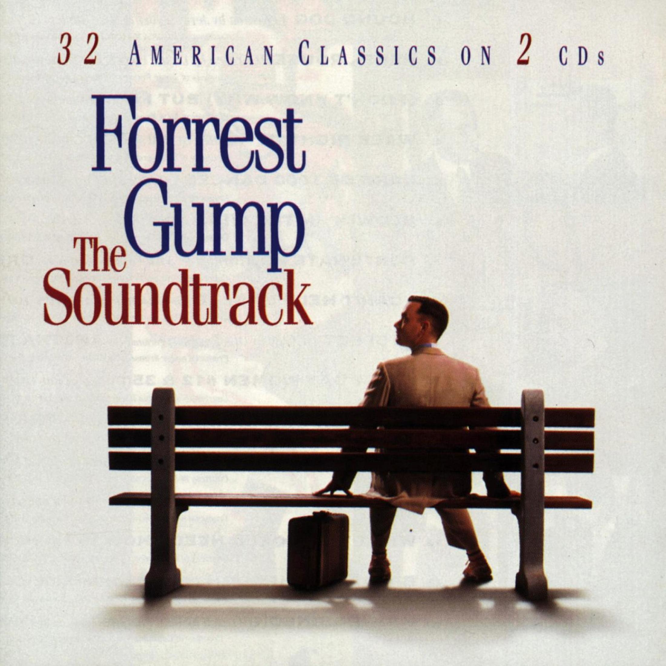 Uomo seduto su una panchina con valigia. Titolo: Forrest Gump Soundtrack.