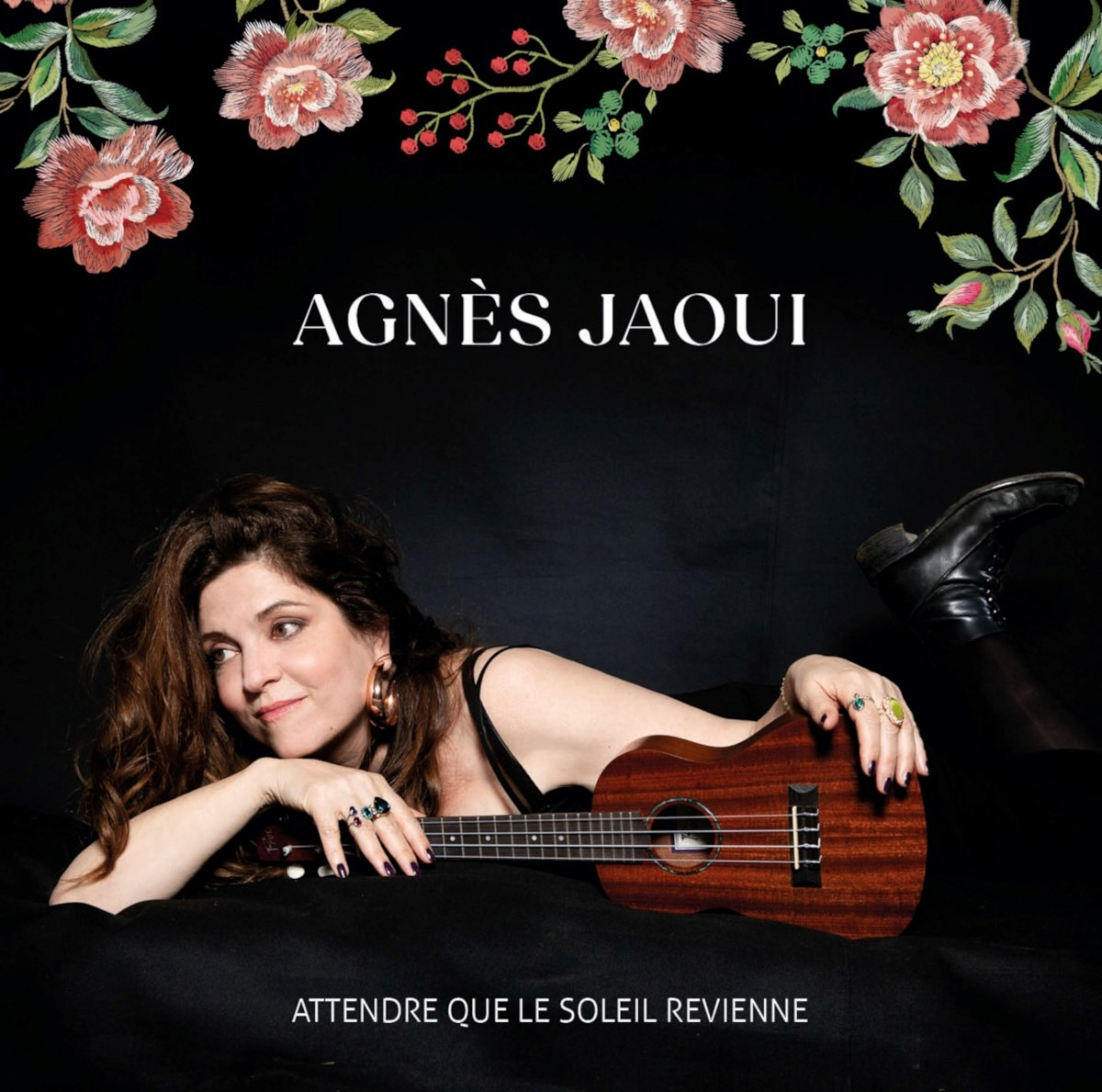 Donna con ukulele su sfondo nero, bordo floreale in alto.