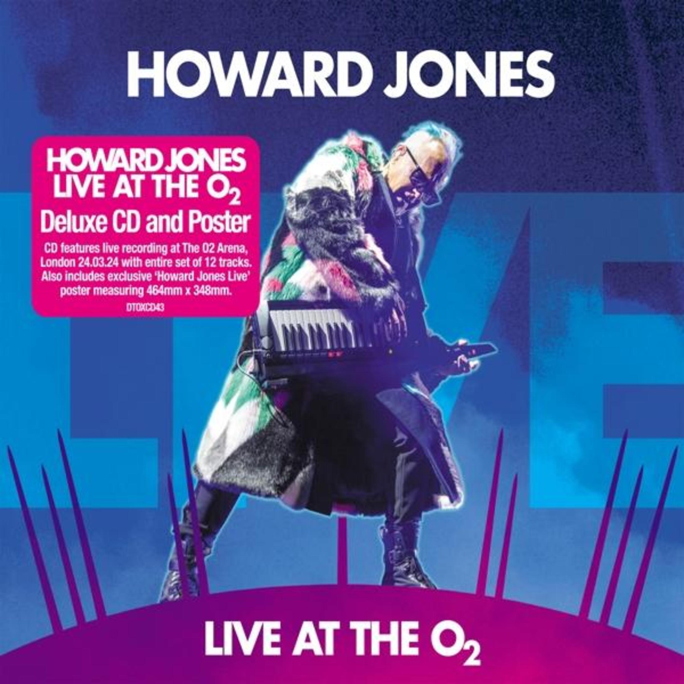 Howard Jones suona Keytar dal vivo, indossa giacca colorata. Testo e logo.