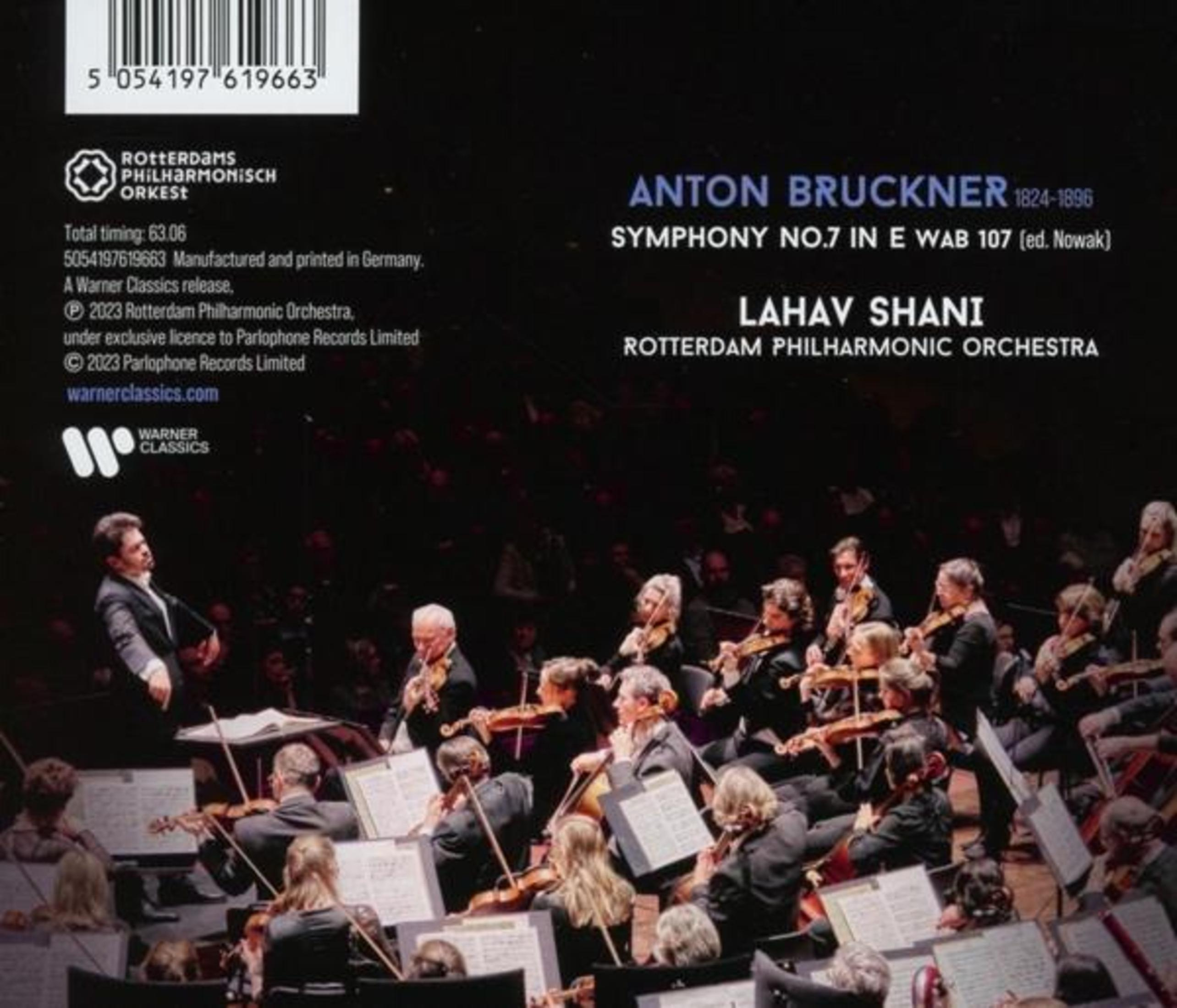 Un direttore e un'orchestra suonano strumenti su sfondo nero.
