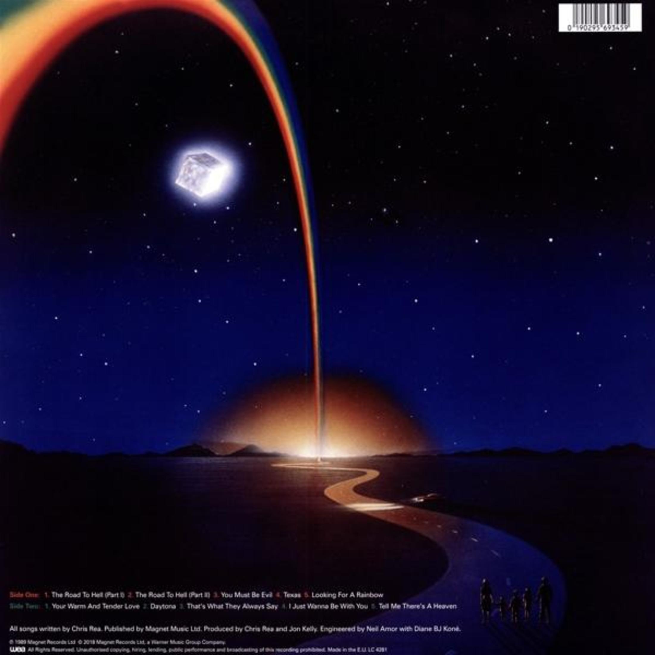Una strada porta a una luce brillante sotto un cielo stellato con un arcobaleno.