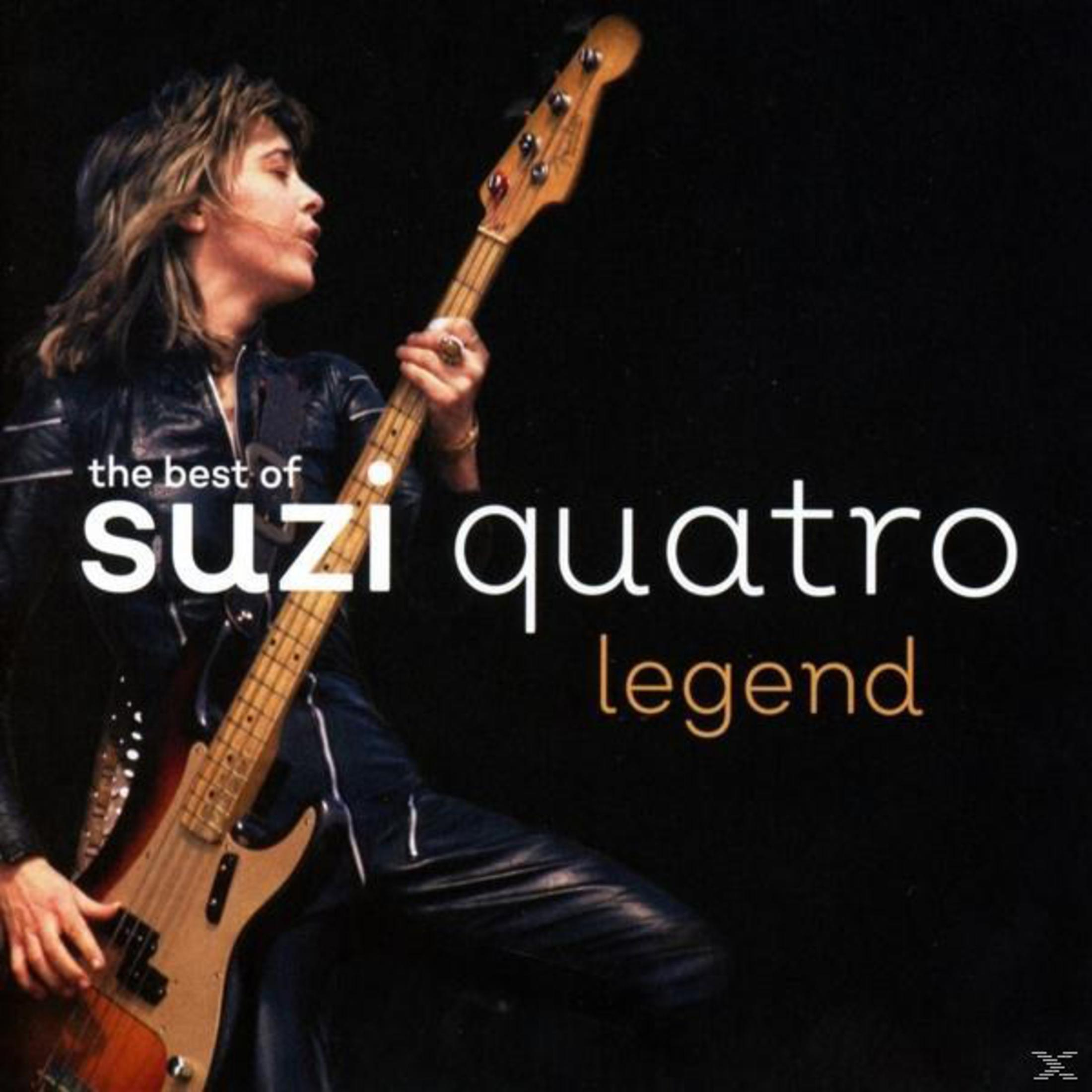 Suzi Quatro suona un basso elettrico su sfondo nero.