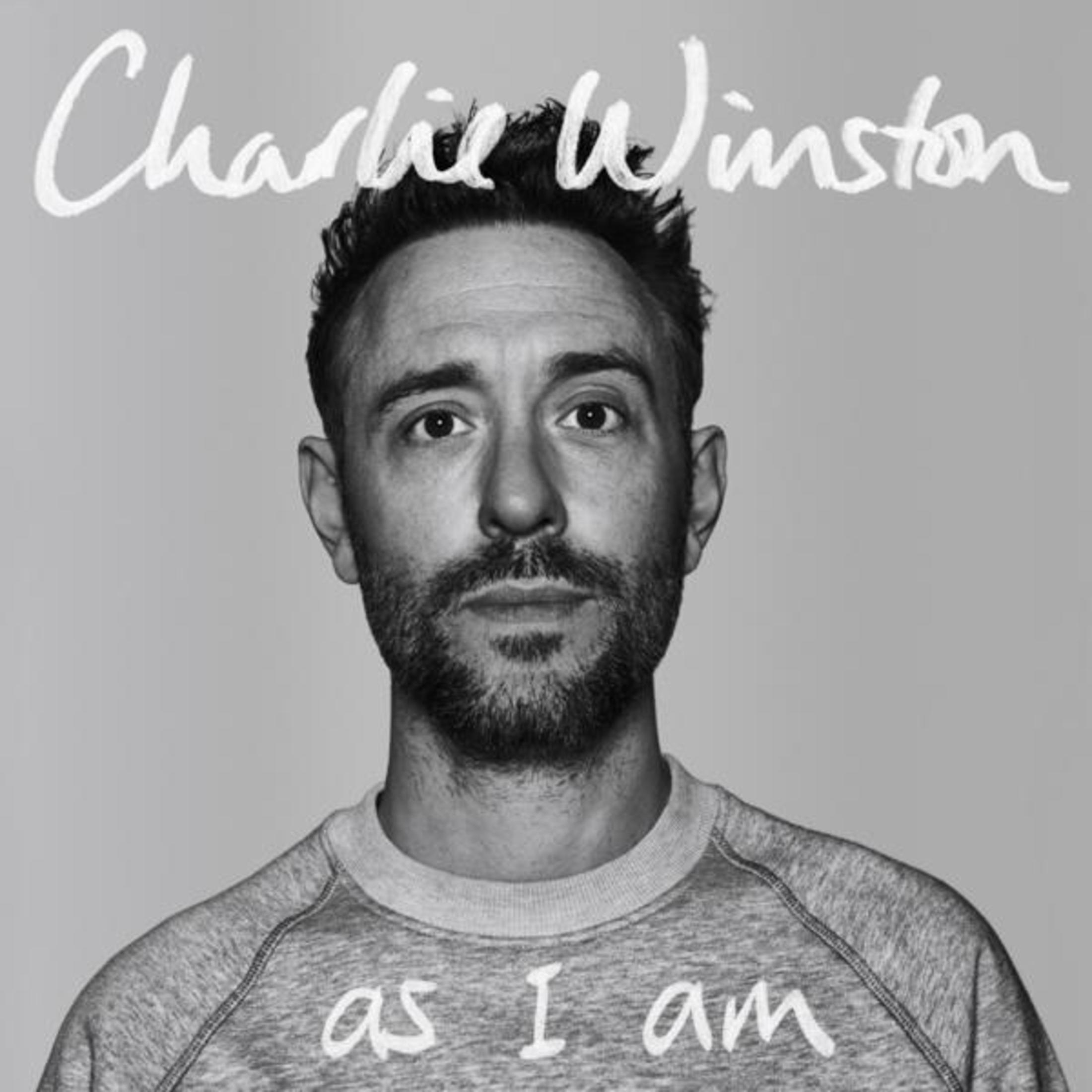 Ritratto di un uomo con la barba che indossa una felpa con scritto 'as I am'.