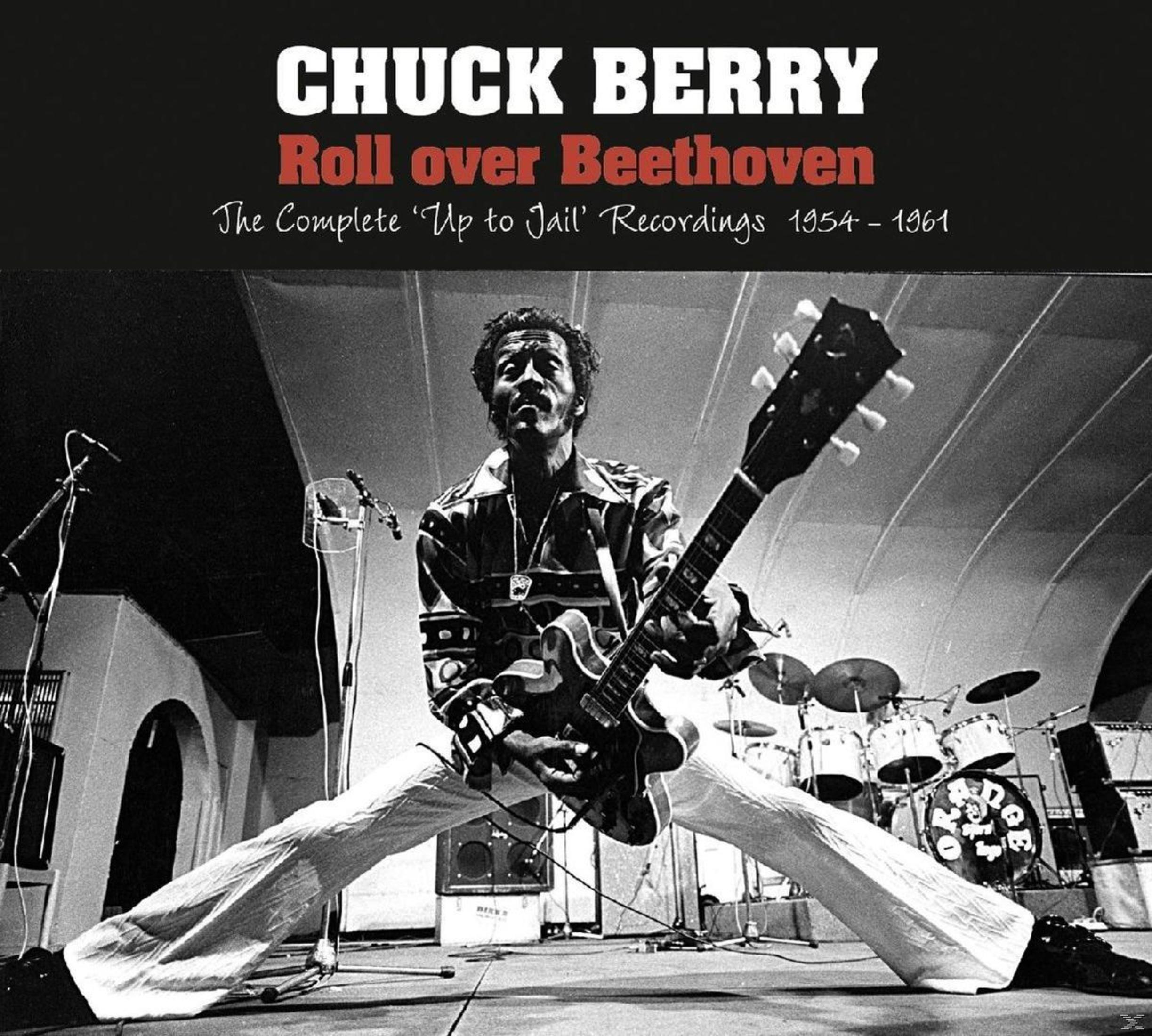 Chuck Berry suona la chitarra sul palco con batteria.