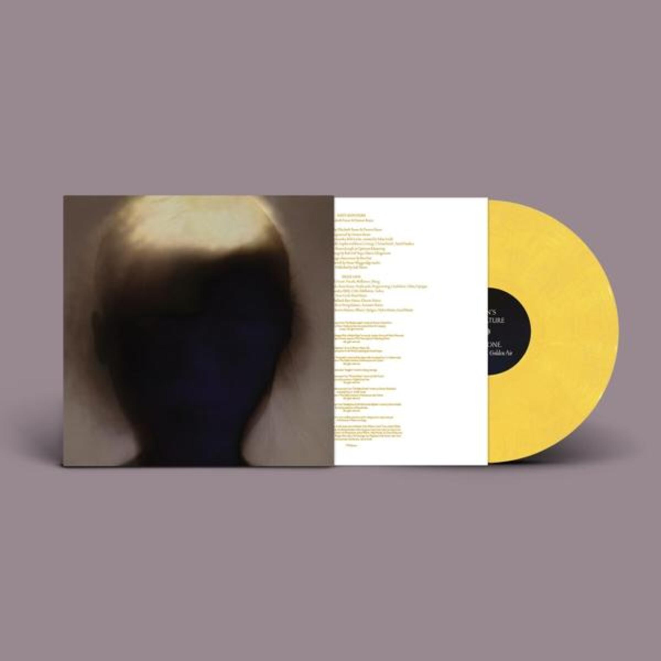 Disco in vinile giallo con copertina di testa sfocata e testi delle canzoni.