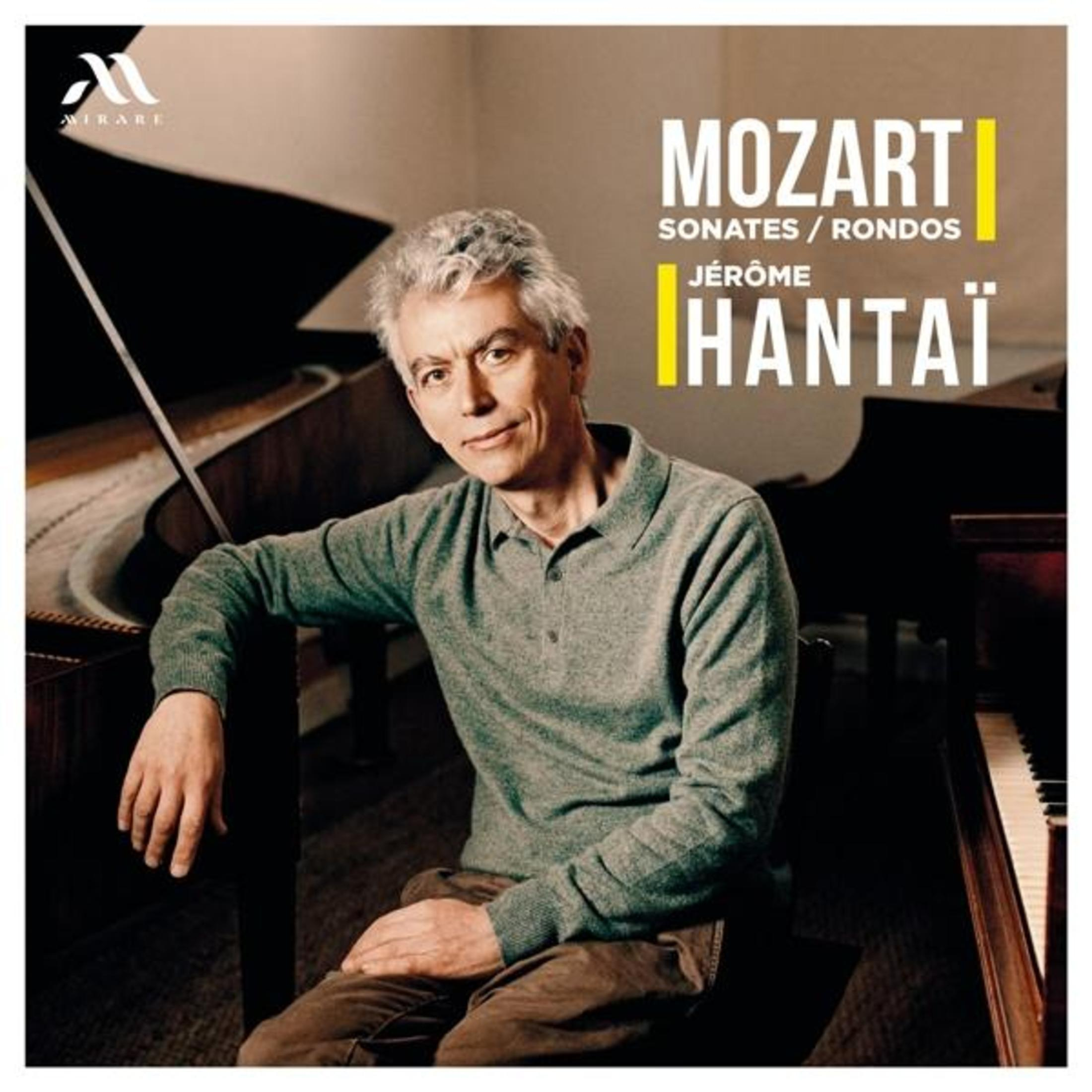 Il pianista Jérôme Hantai è seduto vicino a un pianoforte a coda, con testo 
