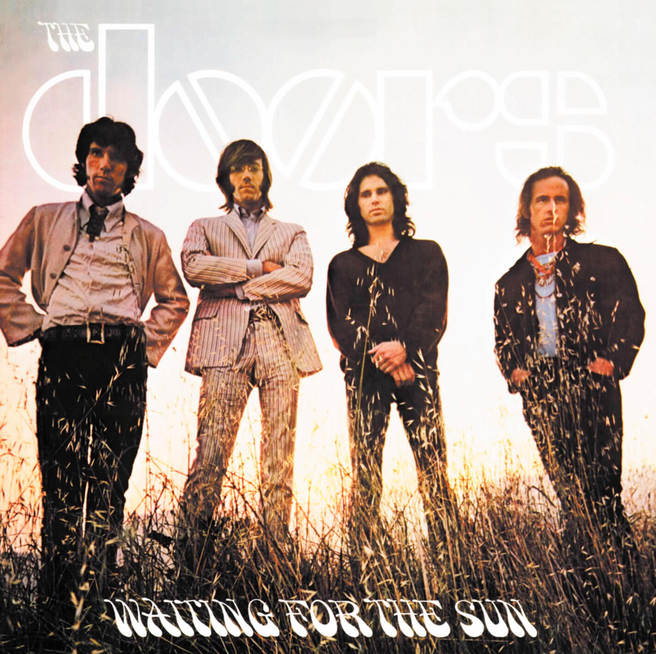Quattro uomini in erba alta davanti a un cielo luminoso. Logo "The Doors" sopra.