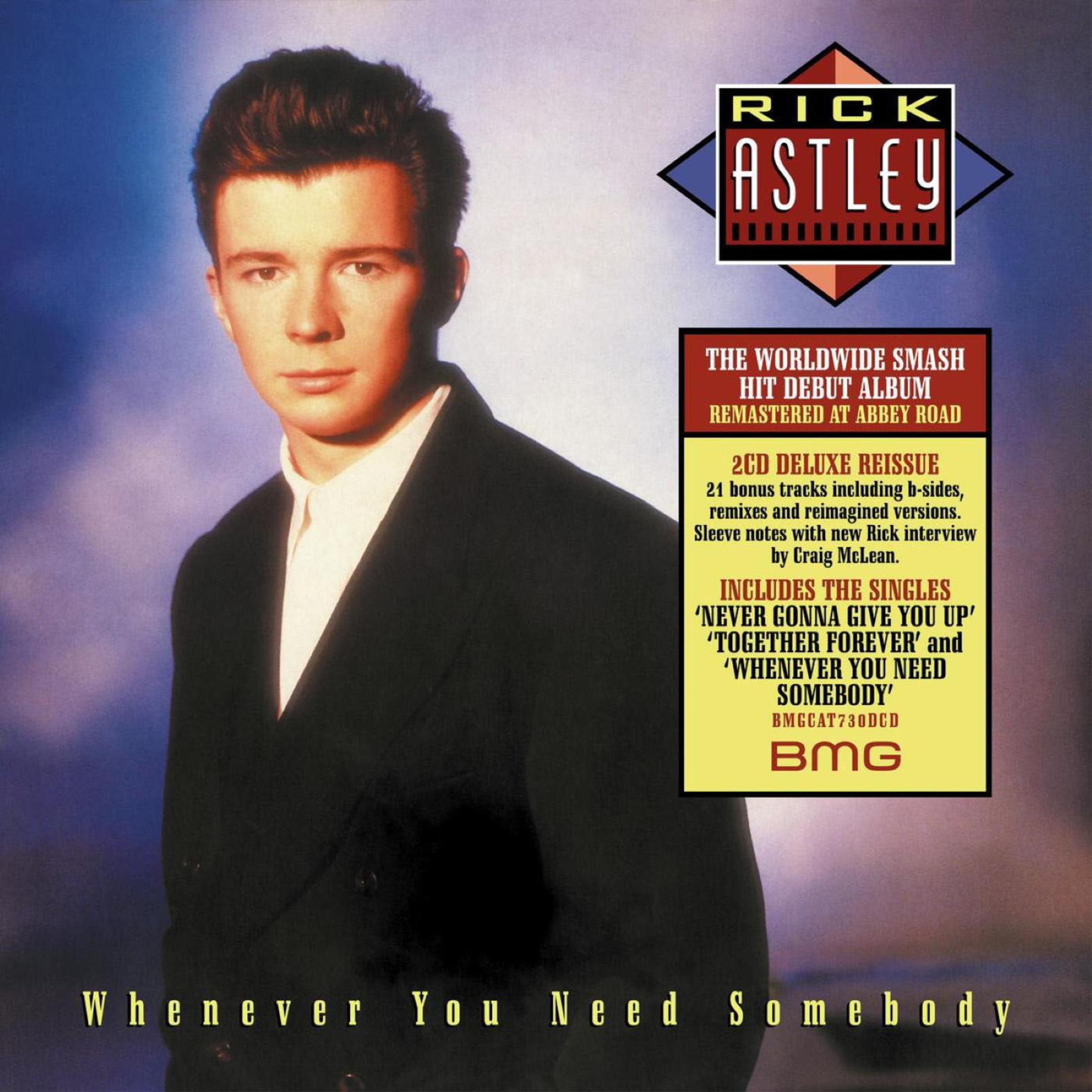 Rick Astley indossa un abito nero e una camicia bianca, su sfondo blu e viola.