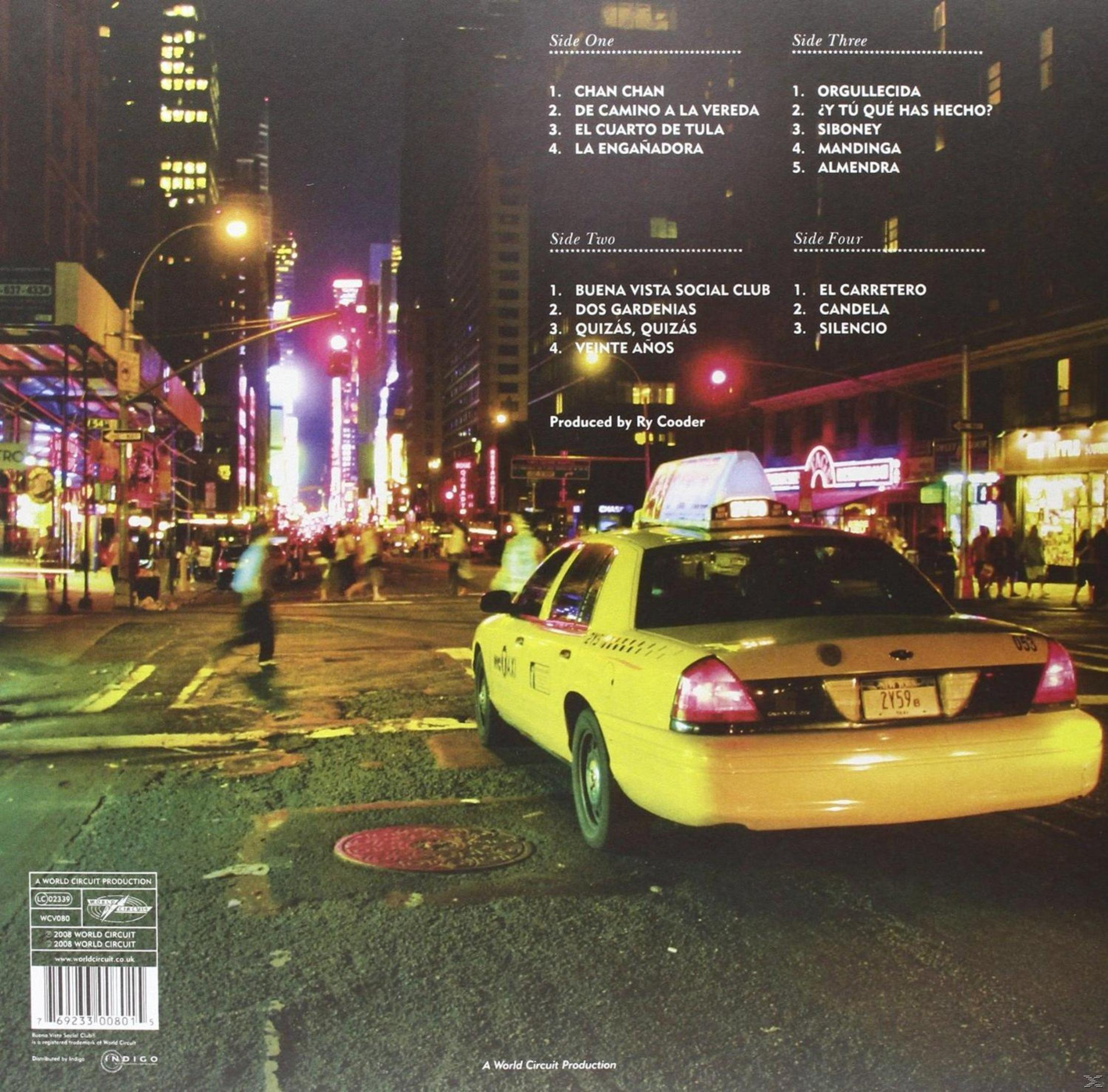 Un taxi giallo di New York in una strada trafficata di notte con grattacieli illuminati.