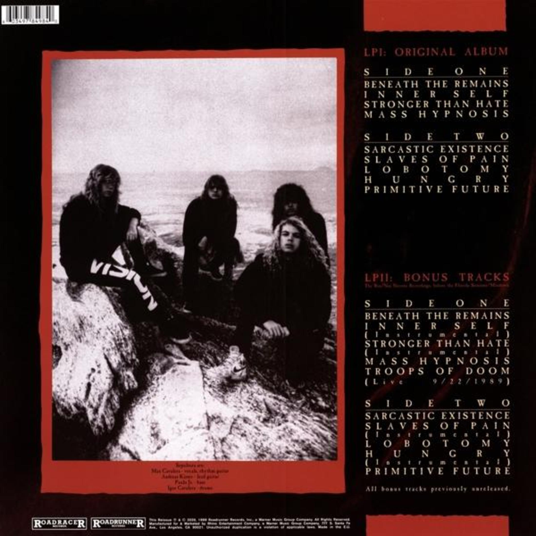Quattro persone in abiti scuri sedute su rocce. Tracklist album nello sfondo.