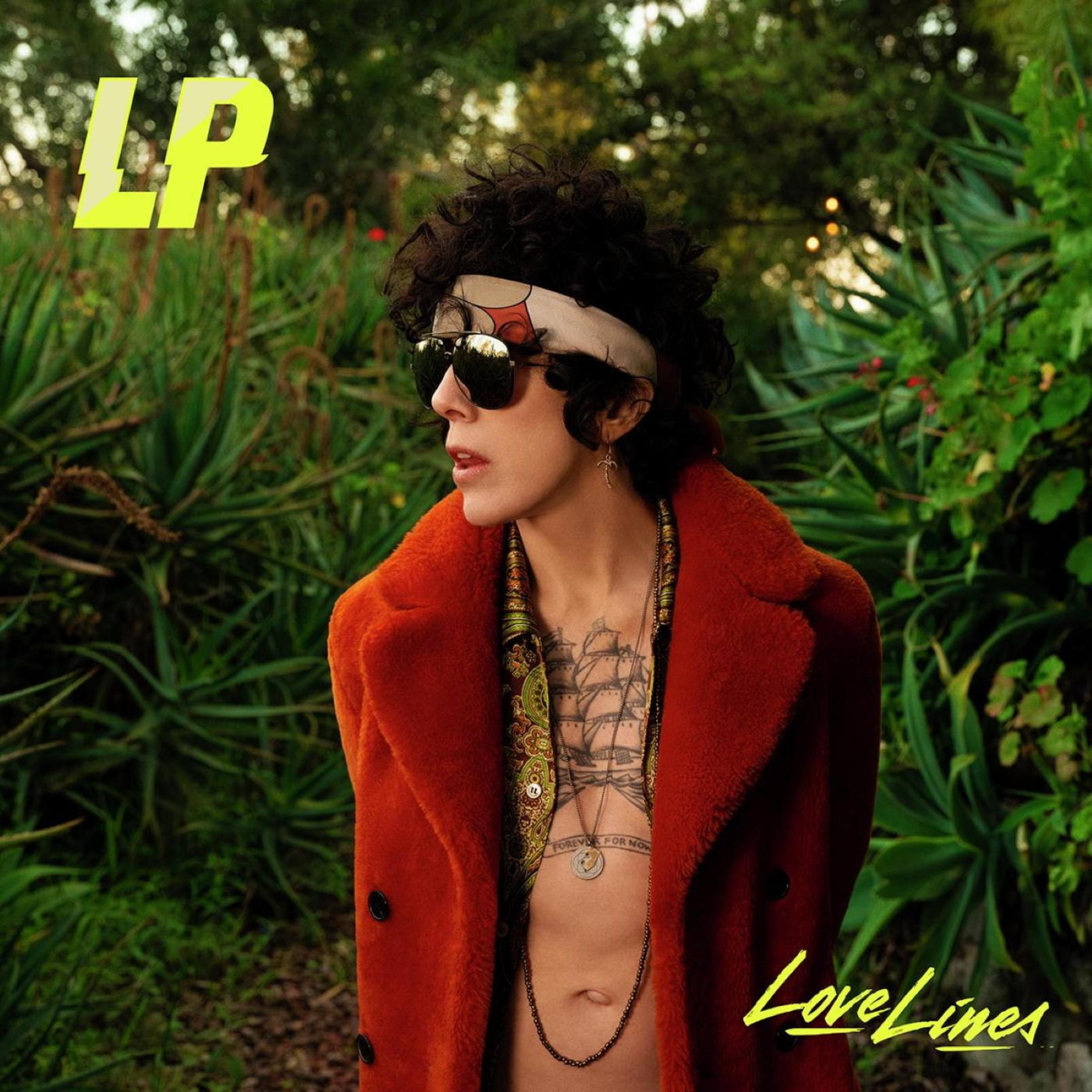 LP in cappotto arancione con tatuaggi, all'aperto.