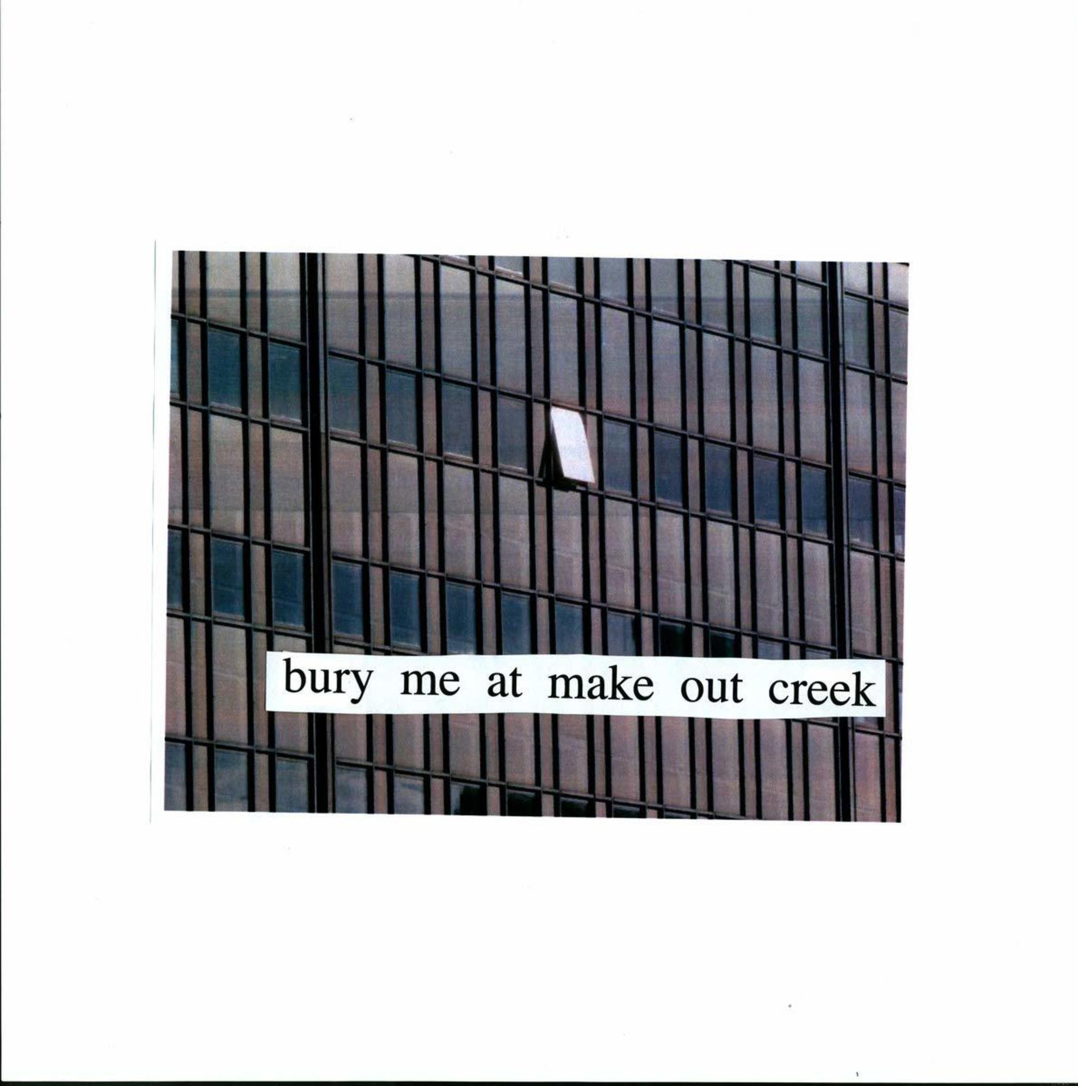Edificio con facciata in vetro e una finestra aperta. Testo: bury me at make out creek.