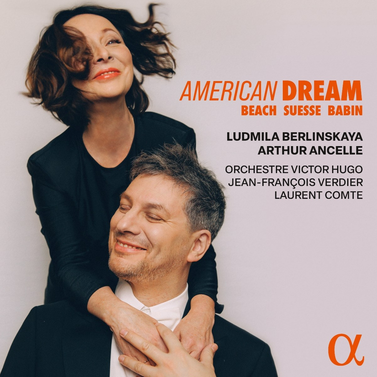 Un uomo e una donna si abbracciano. "American Dream" è in alto.