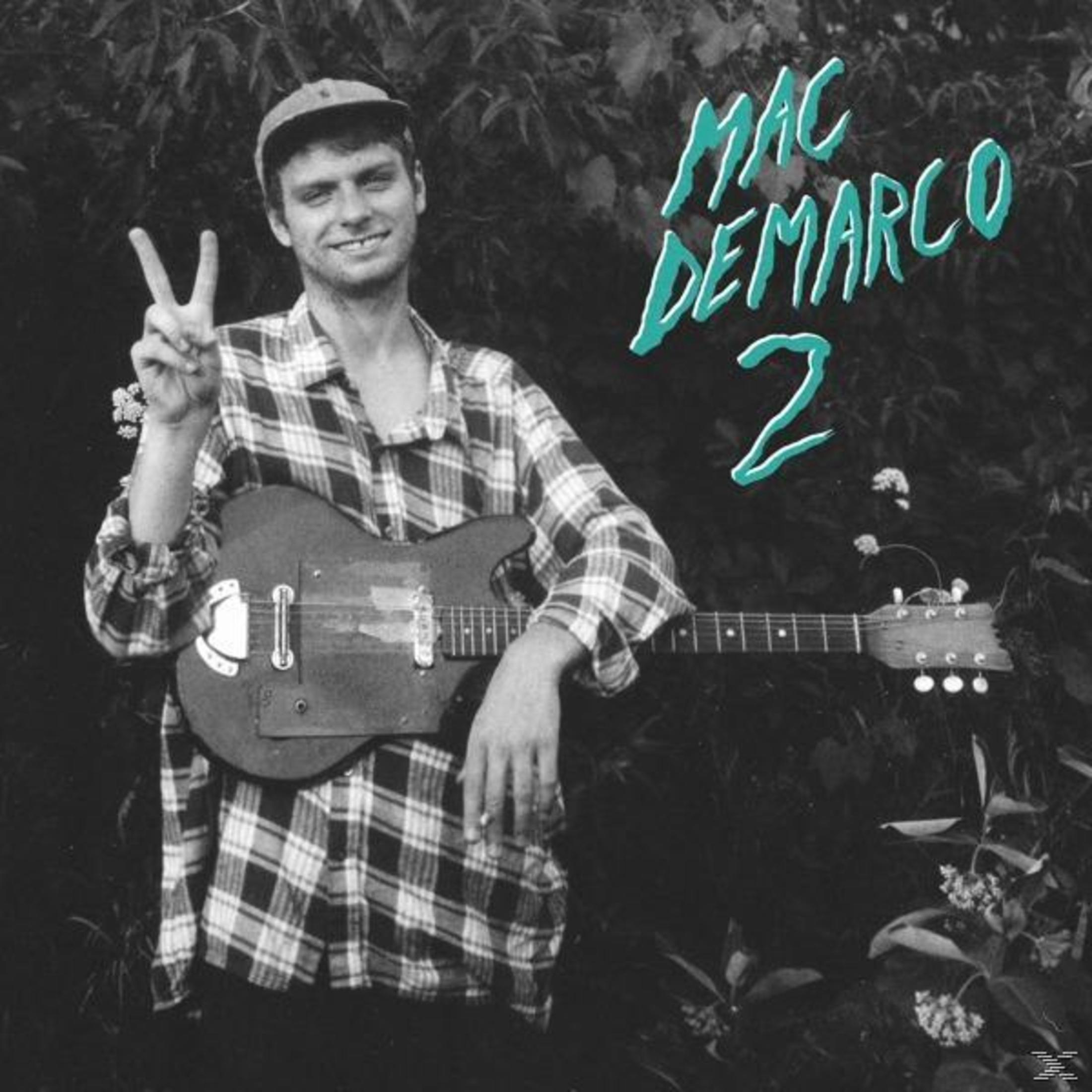 Uomo con chitarra e testo "MAC DEMARCO 2" che fa un segno V.