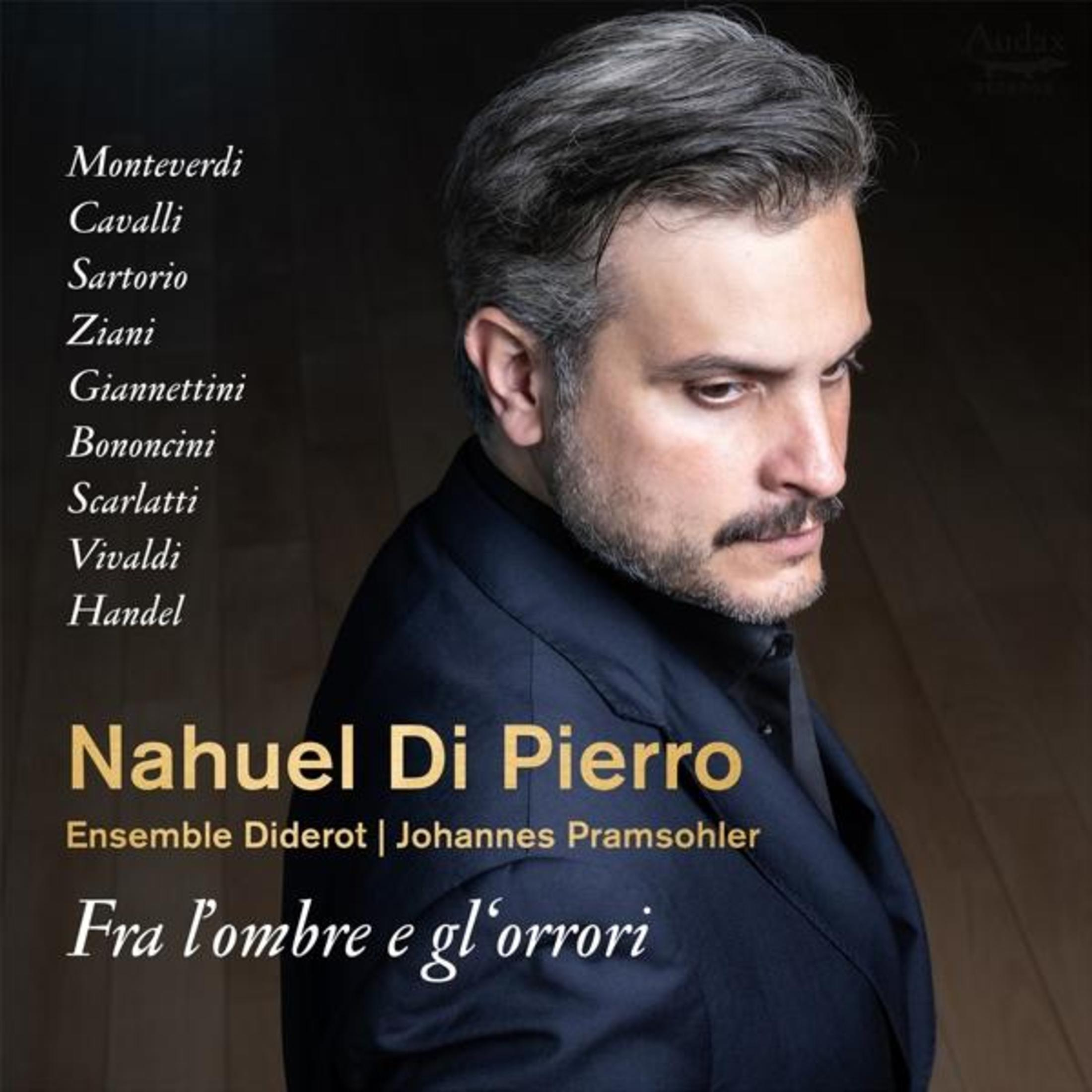 Un uomo con capelli e barba scuri indossa una giacca blu scuro. Elenco compositori, titolo e nomi.