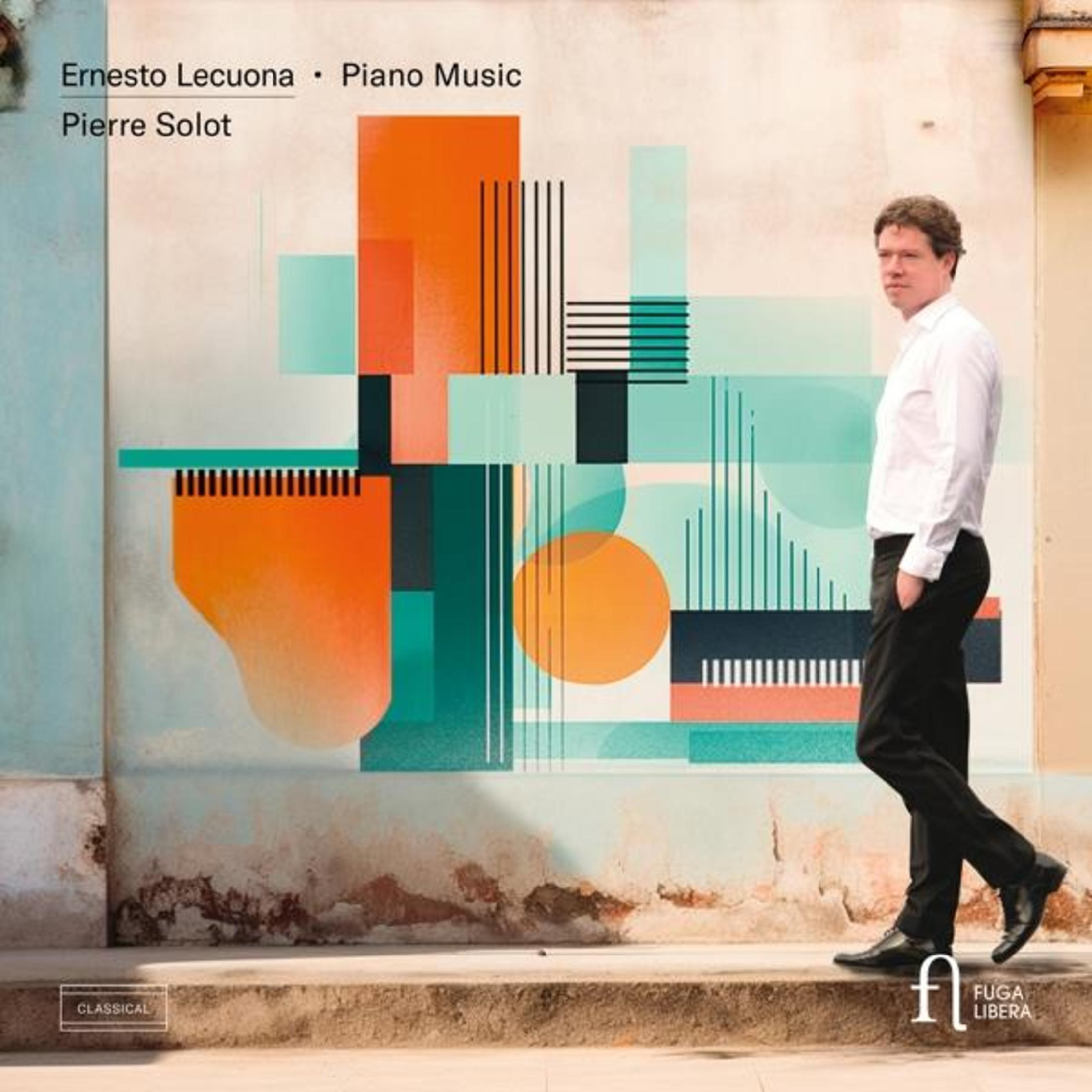 Uomo in camicia bianca e pantaloni neri davanti a un'arte murale astratta.
