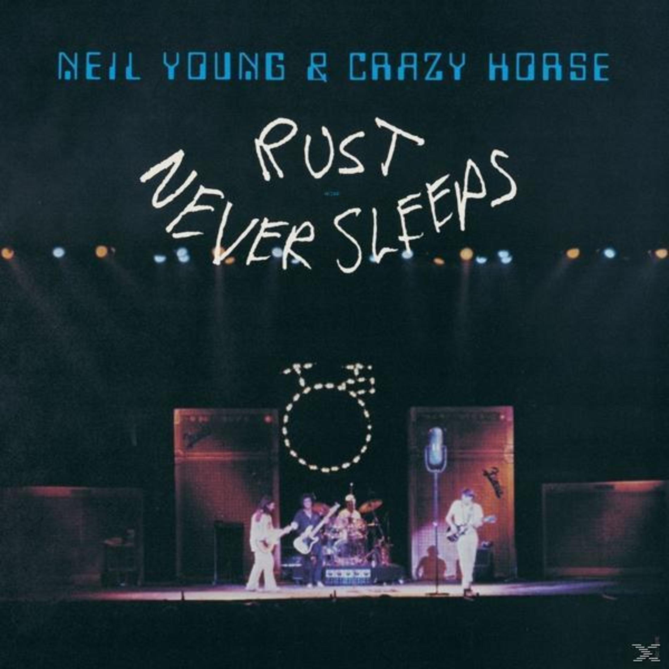 Neil Young & Crazy Horse dal vivo sul palco. Batterista e chitarristi.