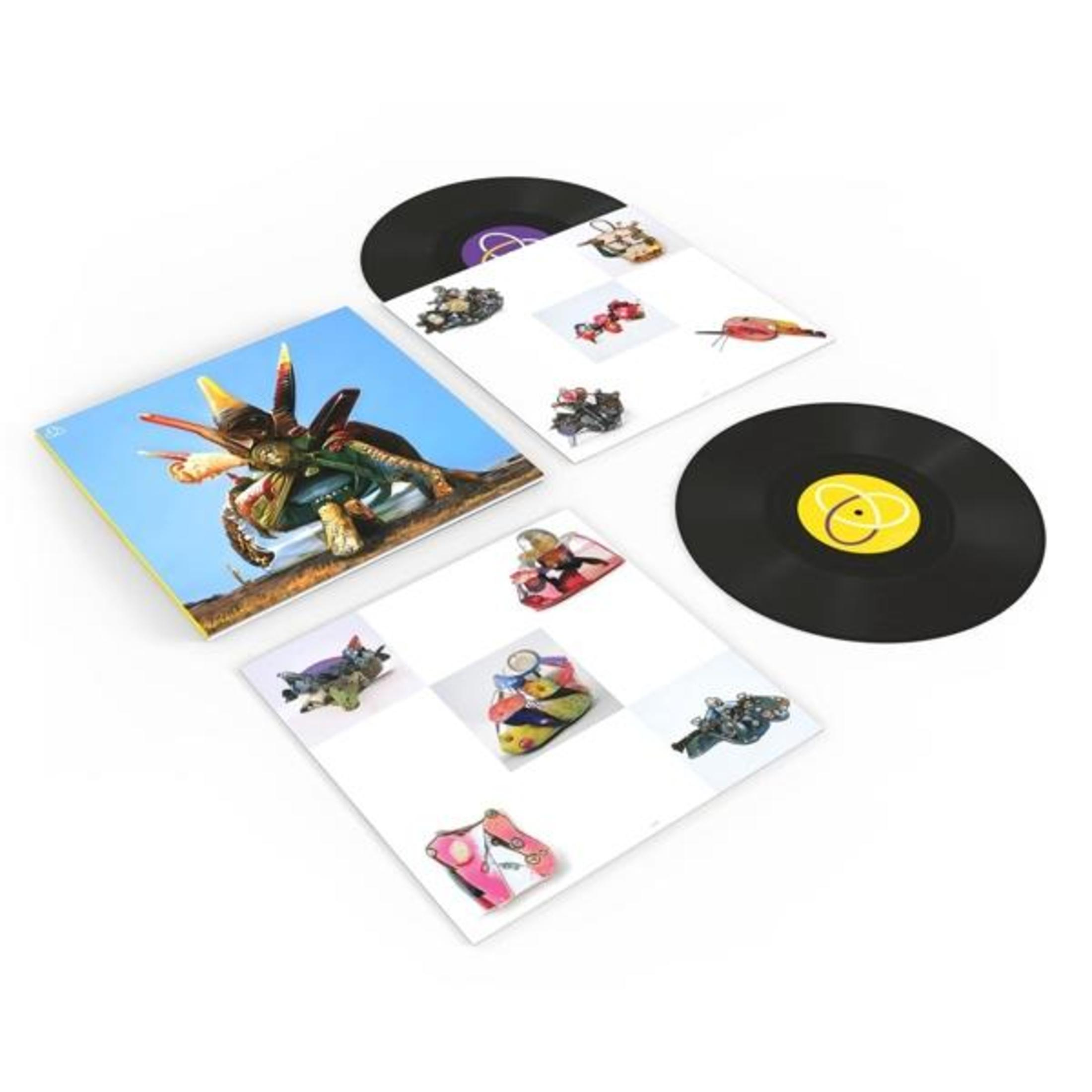 Una copertina di un disco con una creatura bizzarra e due dischi in vinile neri.