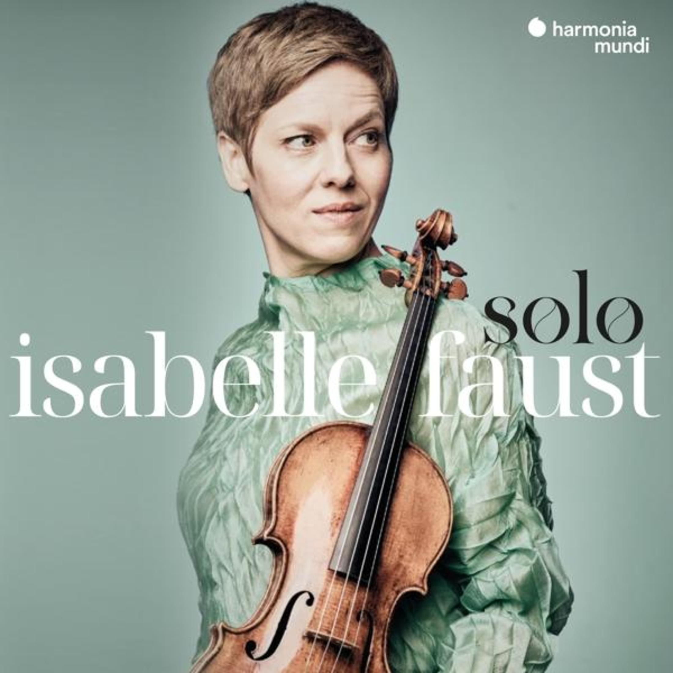 Isabelle Faust con un violino in un abito turchese.