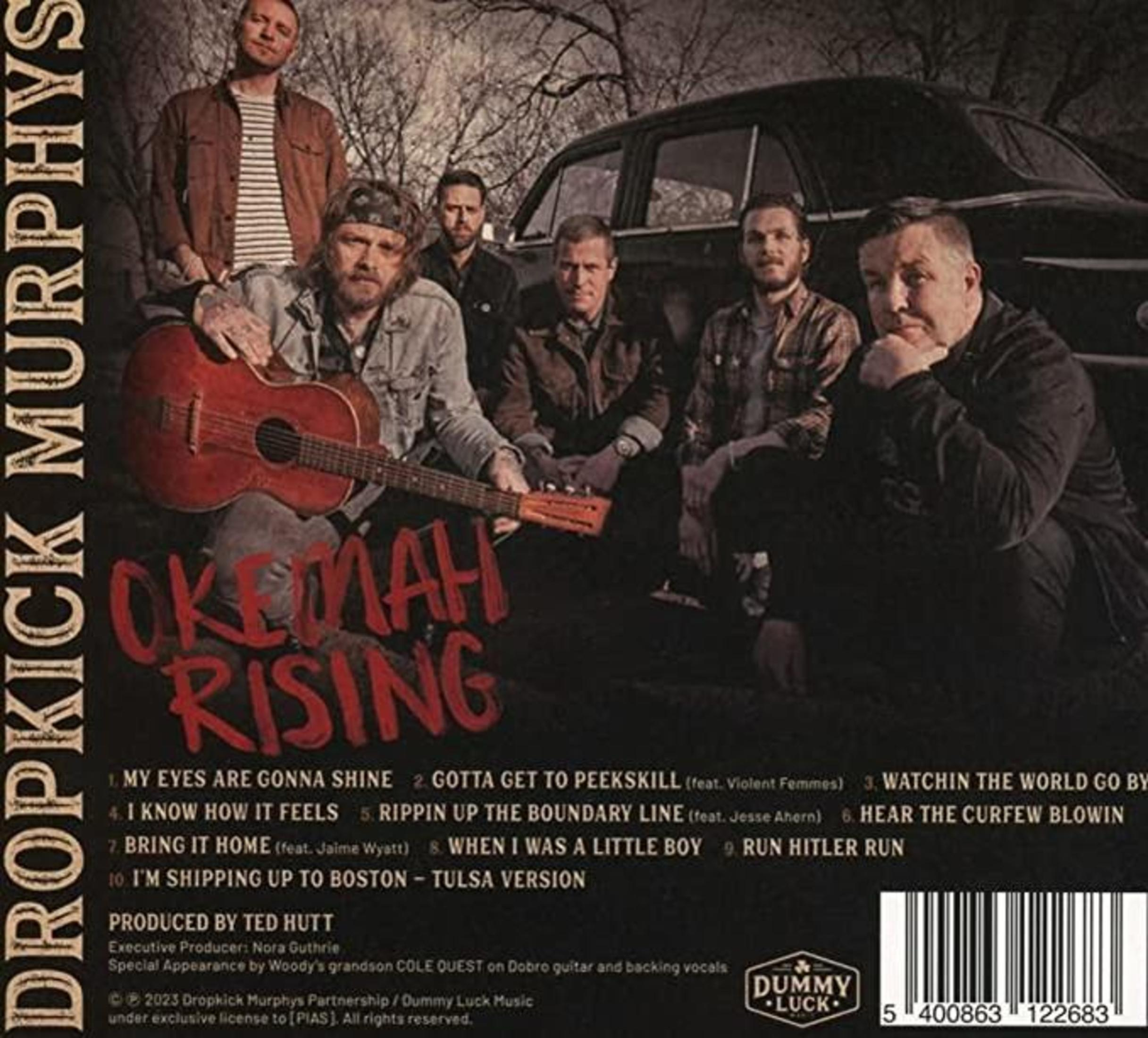 Cinque uomini posano davanti a un'auto, uno tiene una chitarra. Copertina album.