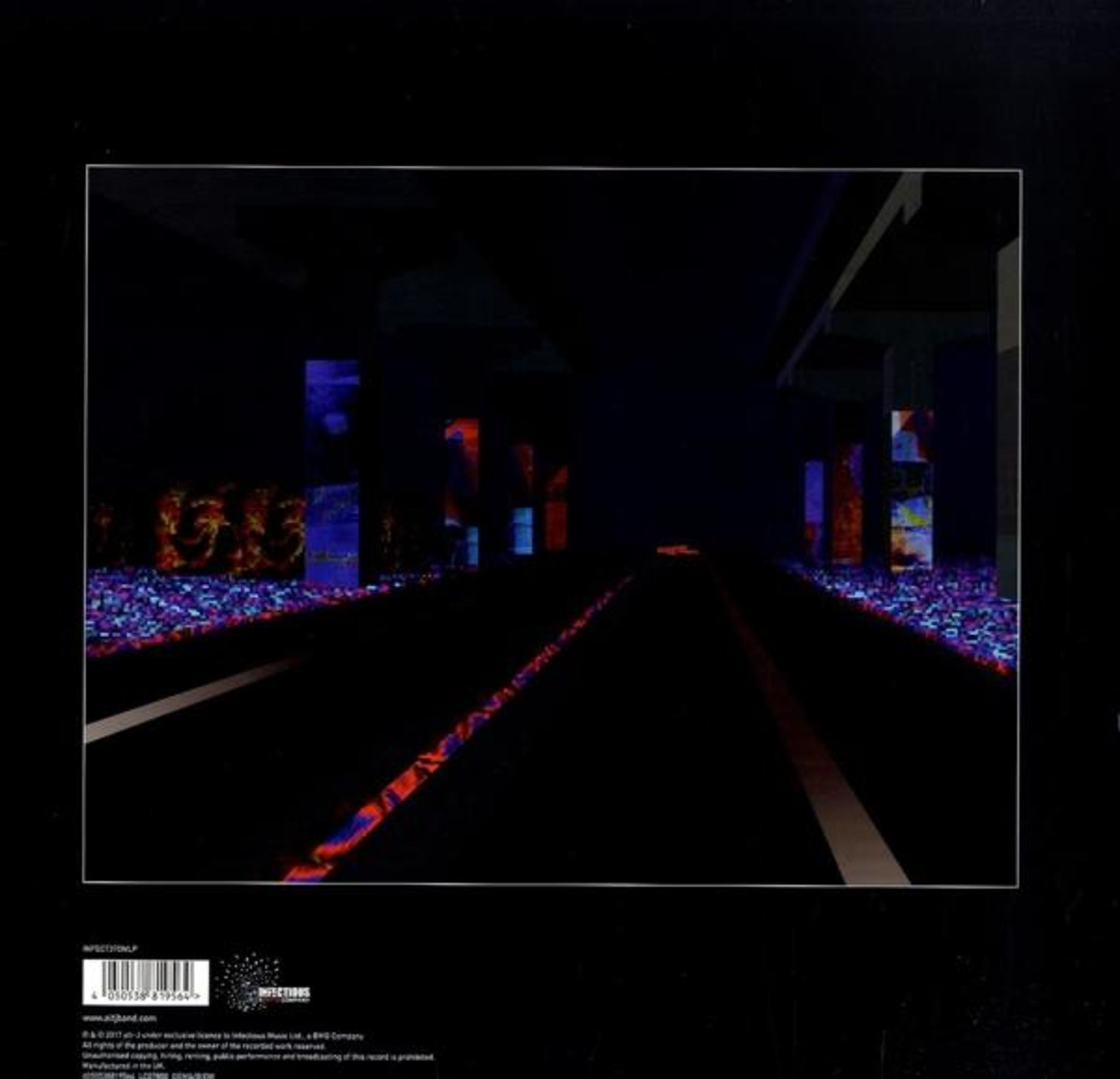 Strada futuristica scura con pilastri e luci colorate.