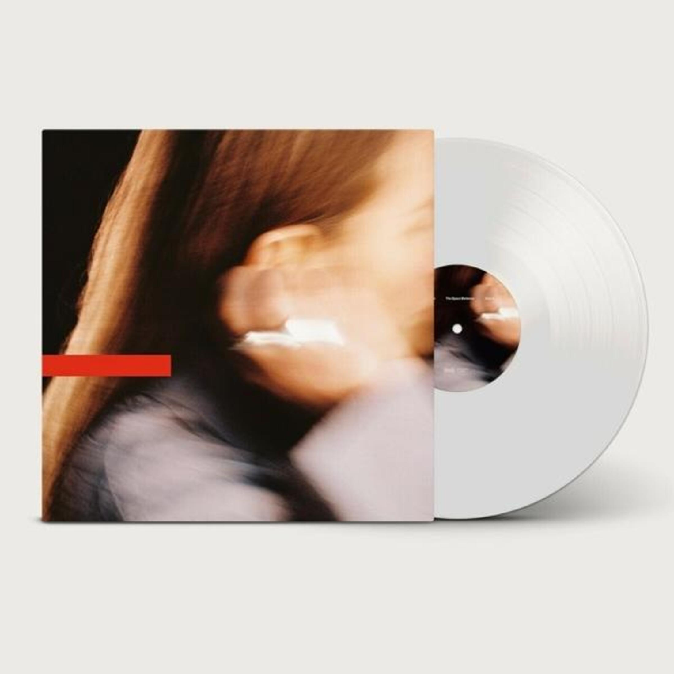 Una copertina di vinile bianca con linea rossa e ritratto sfocato.